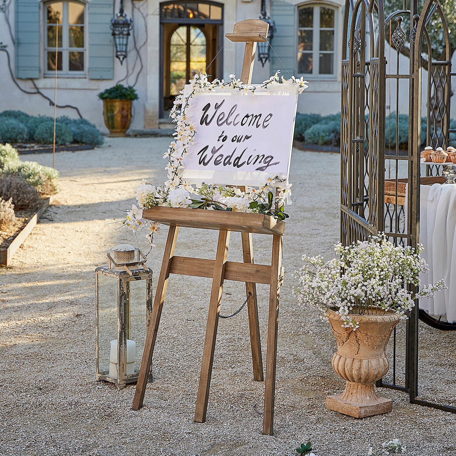 Staffelei Handan Holzs easel mit Blumen dekoriert und Willkommensschild für Hochzeit im Garten