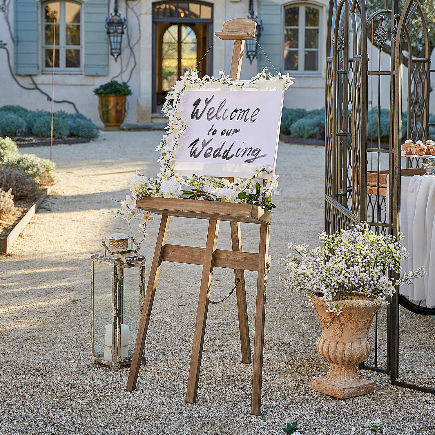 Staffelei Handan Holzs easel mit Blumen dekoriert und Willkommensschild für Hochzeit im Garten