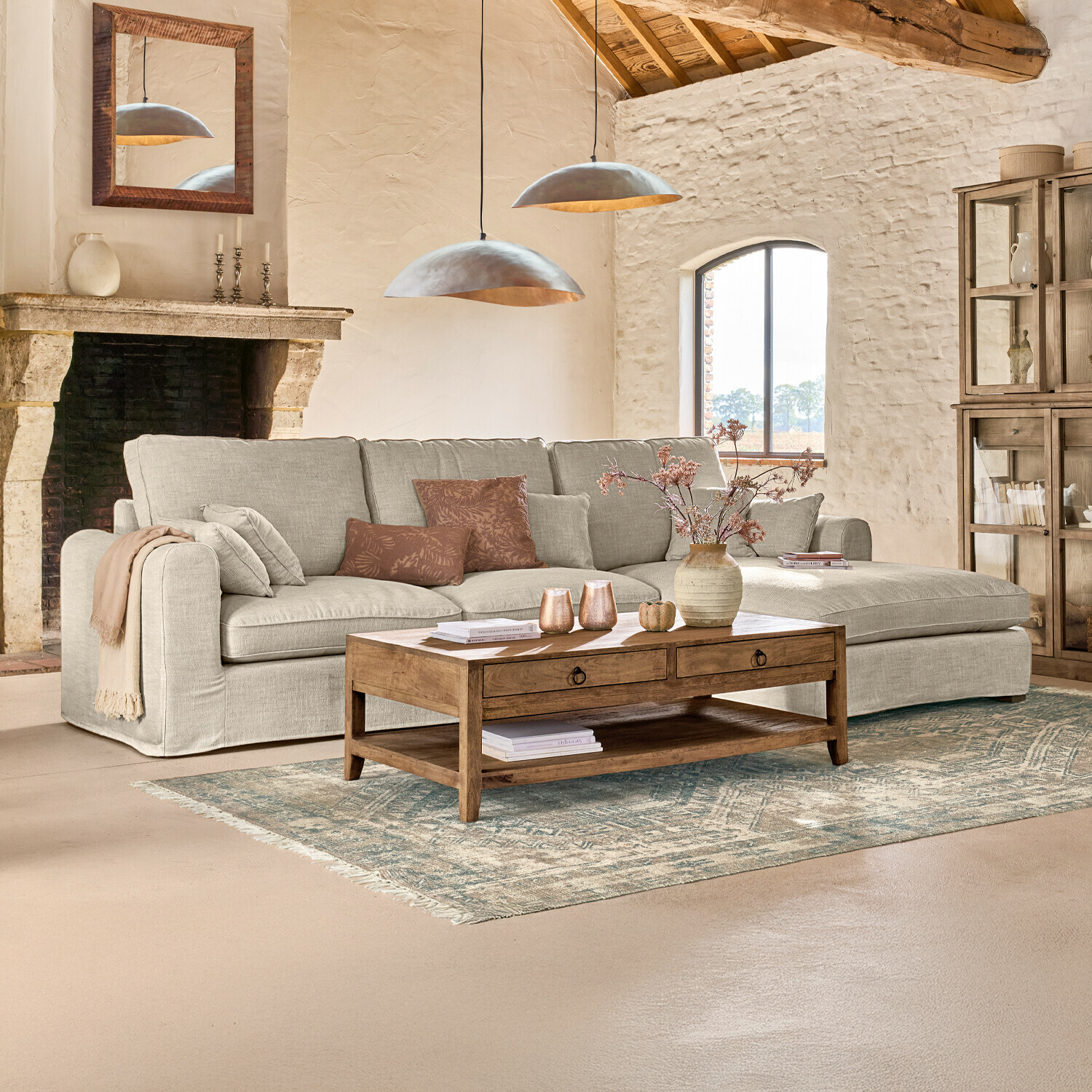 Gemütliches Wohnzimmer mit beigem Stoff-Ecksofa und Holzcouchtisch auf gemustertem Teppich