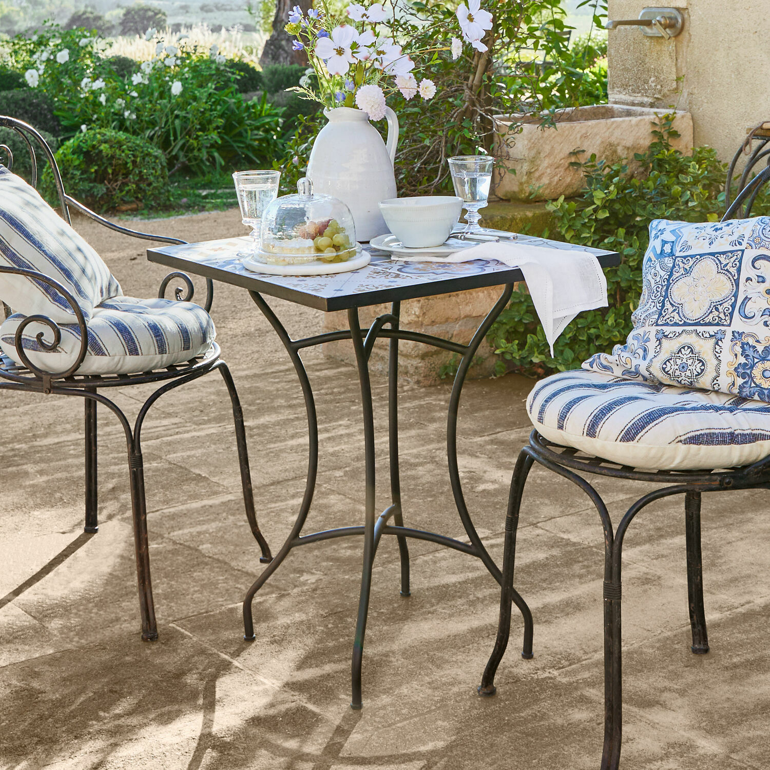 Tisch Céligny Metall-Gartentisch mit quadratischer Platte und zwei Stühlen mit blau gestreiften Polstern