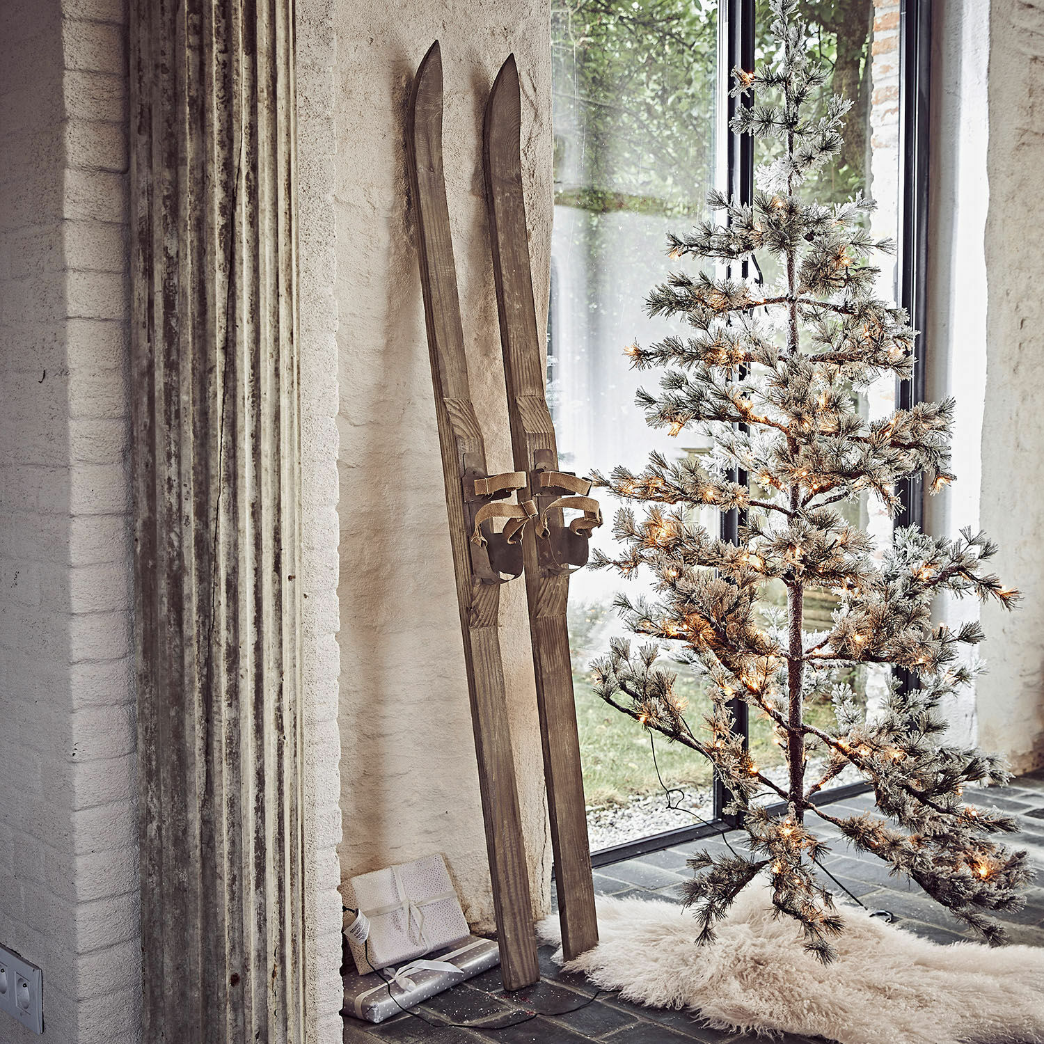 Deko-Ski 2er Set Lambeth Vintage Holzski neben beleuchtetem künstlichen Weihnachtsbaum auf weißem Teppichboden