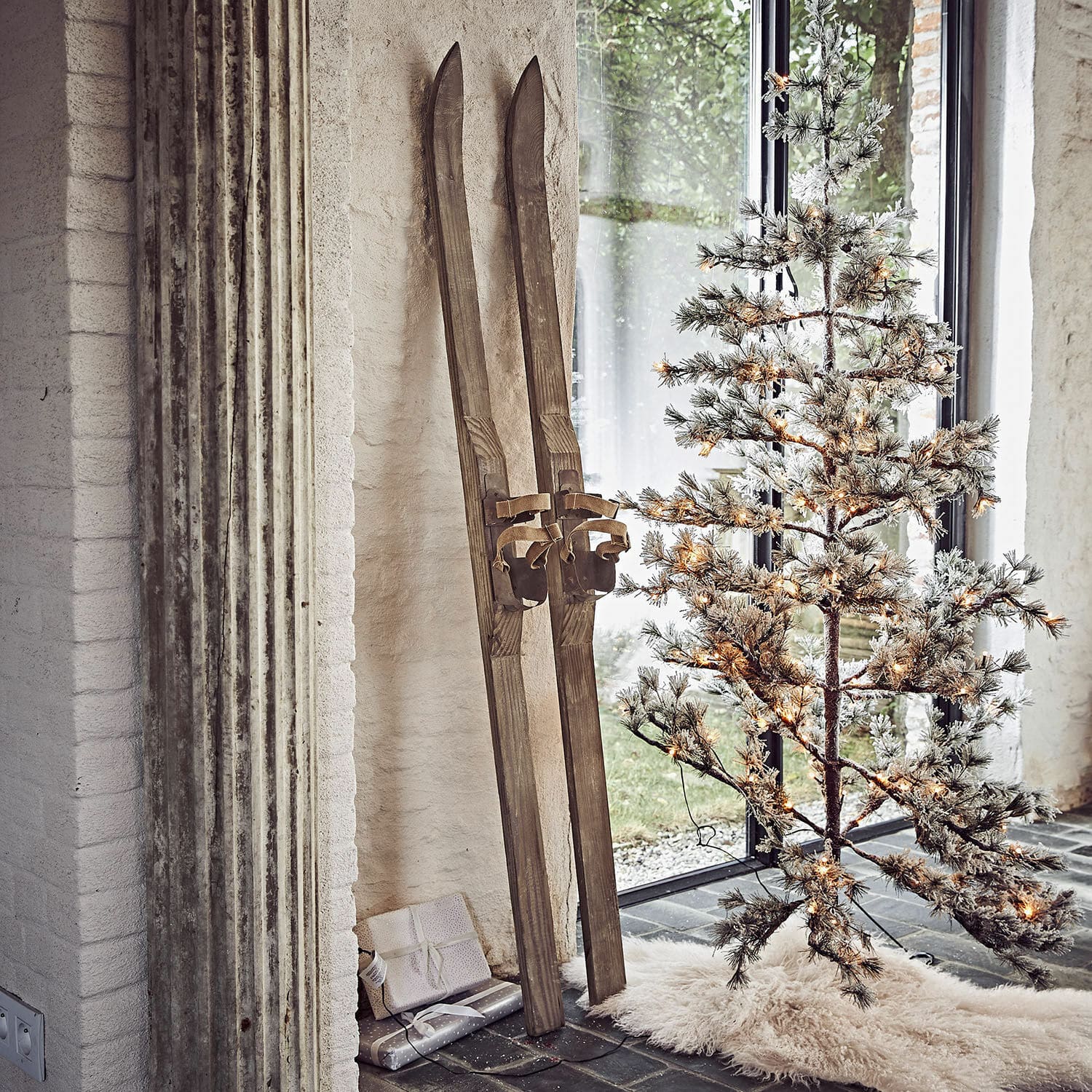 Deko-Ski 2er Set Lambeth Vintage Holzski neben beleuchtetem künstlichen Weihnachtsbaum auf weißem Teppichboden