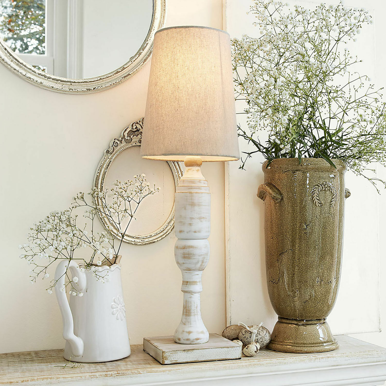 Tischlampe Yernisto Tischlampe aus weißem Holz mit beigem Lampenschirm vor Vintage-Deko mit Vase und Spiegel