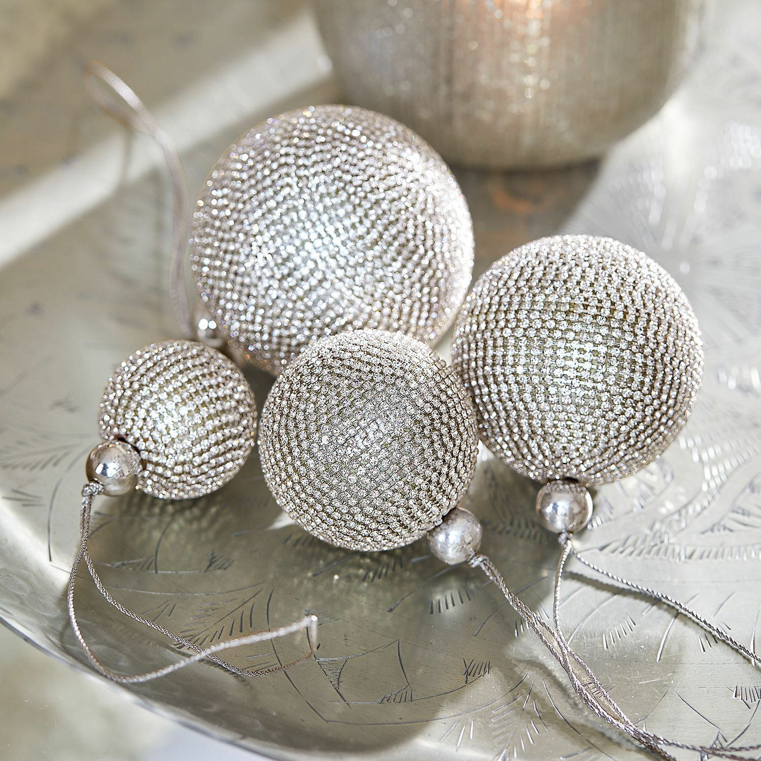 Weihnachtskugel 4er Set Varnor Set aus vier silbernen Weihnachtskugeln mit kleinen Kristallen auf dekorativem Metalltablett