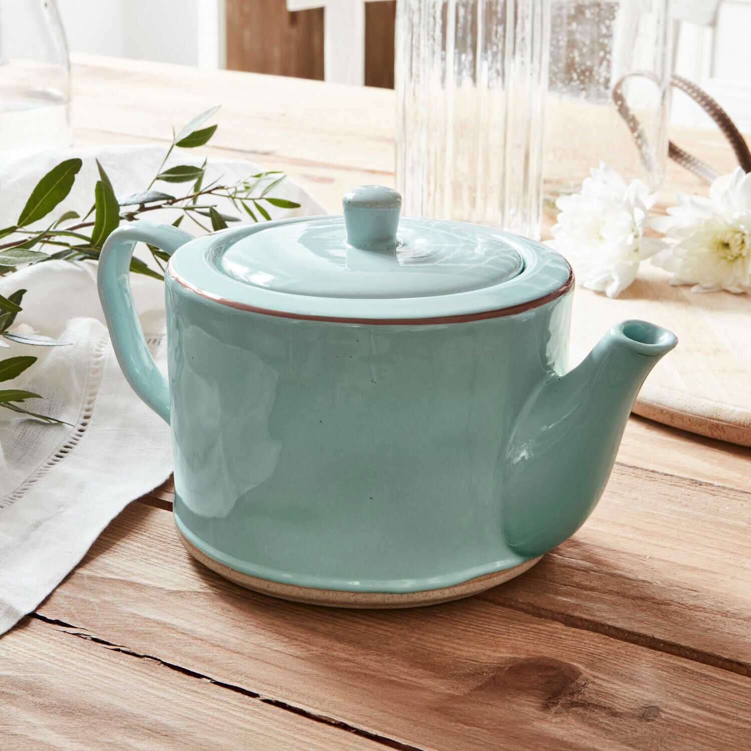Teekanne Biarré Grüne Keramik-Teekanne mit Deckel auf Holztisch mit weißen Blumen und grünen Blättern