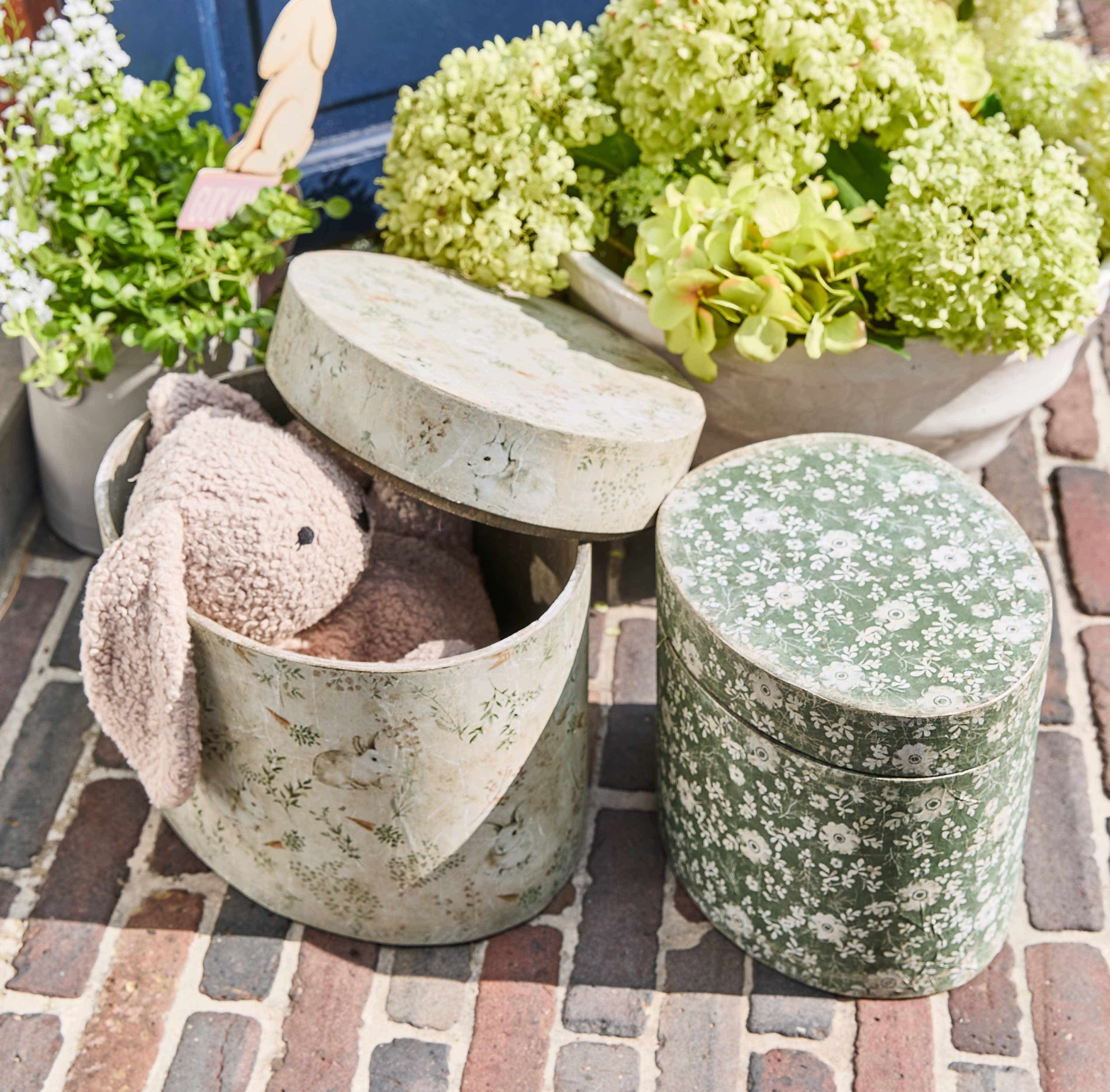 Ovale Dekorationsdosen mit Blumen- und Hasenmotiven, eine mit rosa Plüschhase innen