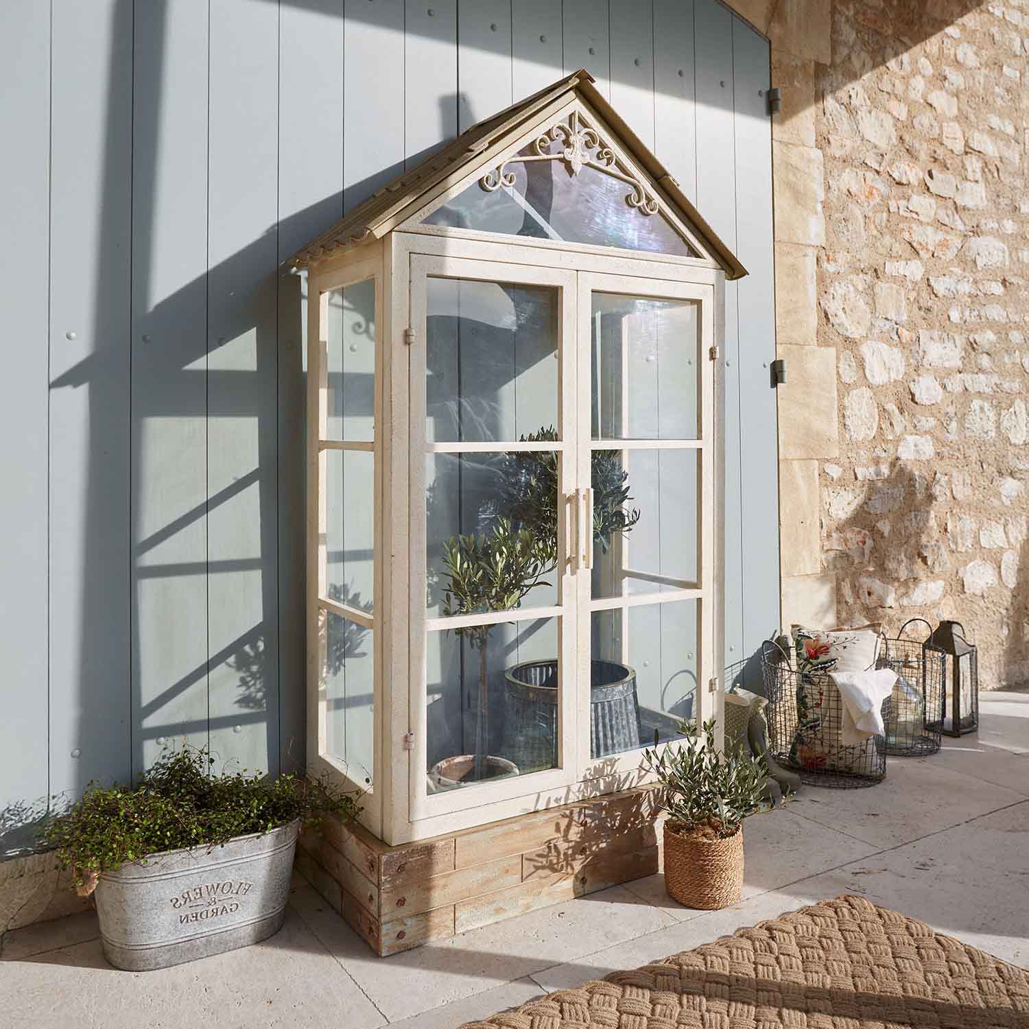 Kleines Gewächshaus aus Metall und Glas in Creme mit Pflanzen, Terrassendekoration
