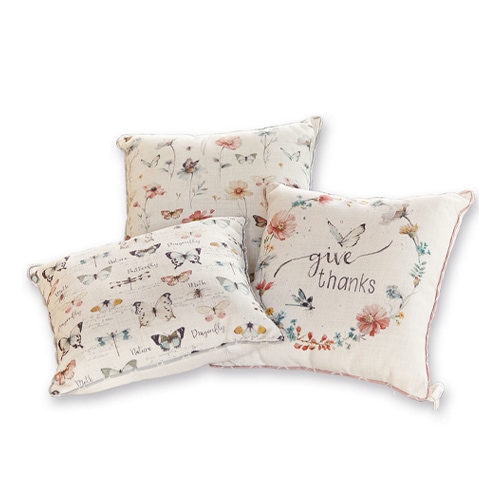 Drei dekorative Baumwollkissen in hellen Farben mit Schmetterlings- und Blumenmotiven