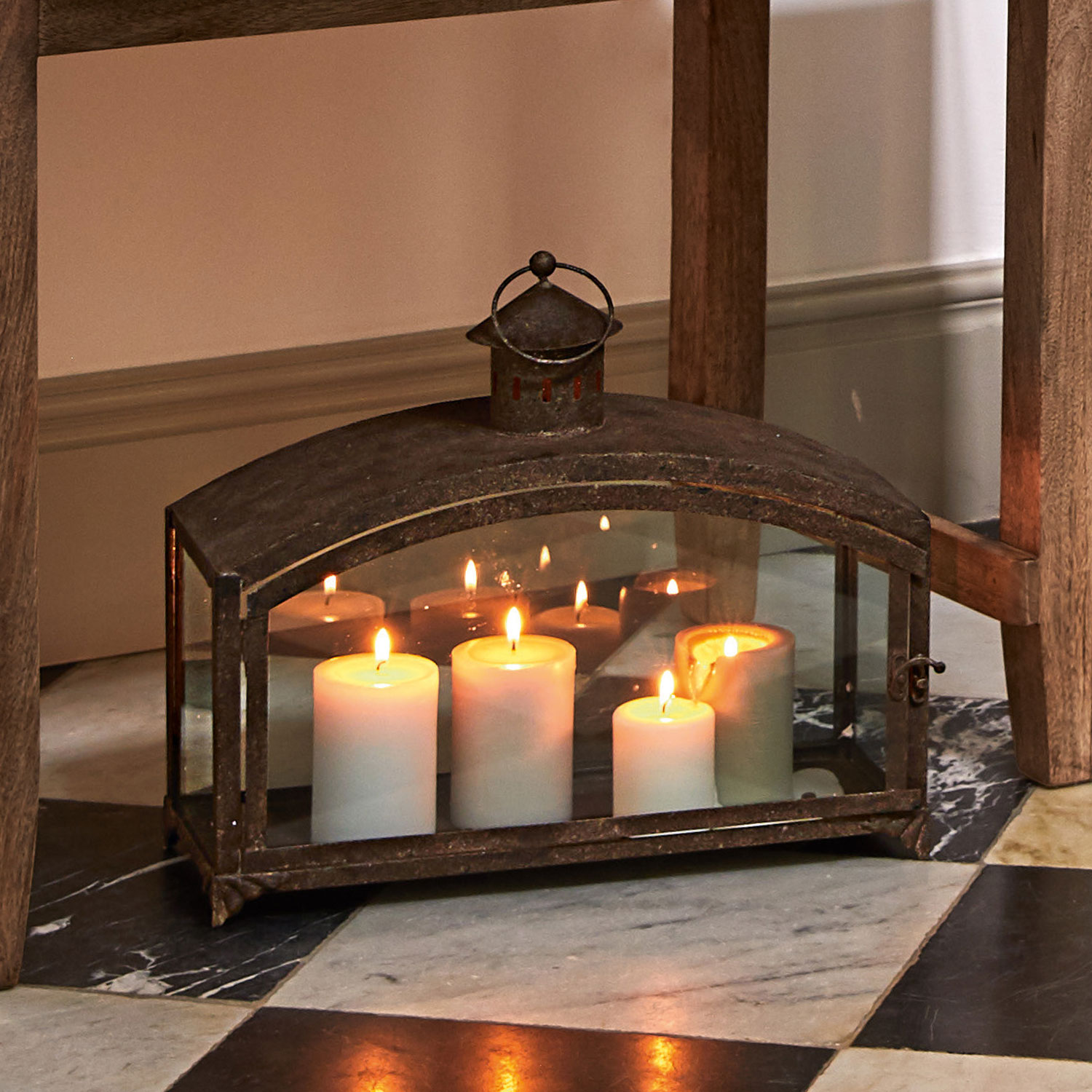 Metalllaterne mit vier weißen Kerzen, rustikales Design, Wohnaccessoire, stimmungsvolle Beleuchtung