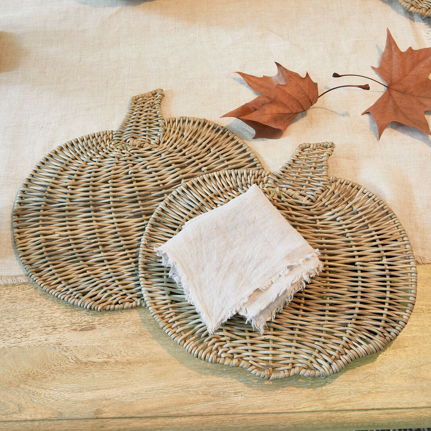 Platzset 2er Set Larivonne Zwei naturfarbene Kürbis-förmige Untersetzer aus Rattan mit Leinenserviette und Herbstblättern
