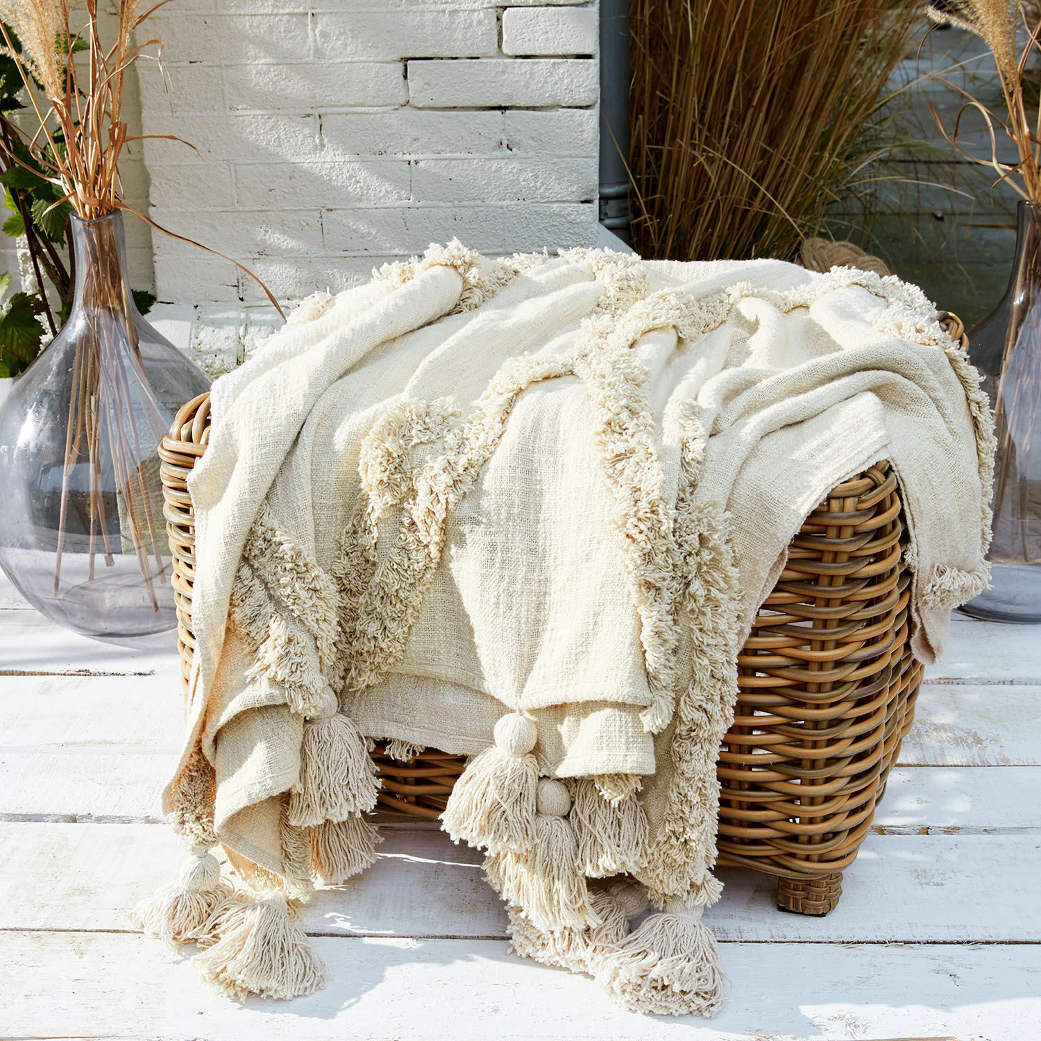 Plaid Linares Cremefarbene Baumwolldecke mit Quasten auf Korb aus Rattan, Wohnaccessoire und Komfort