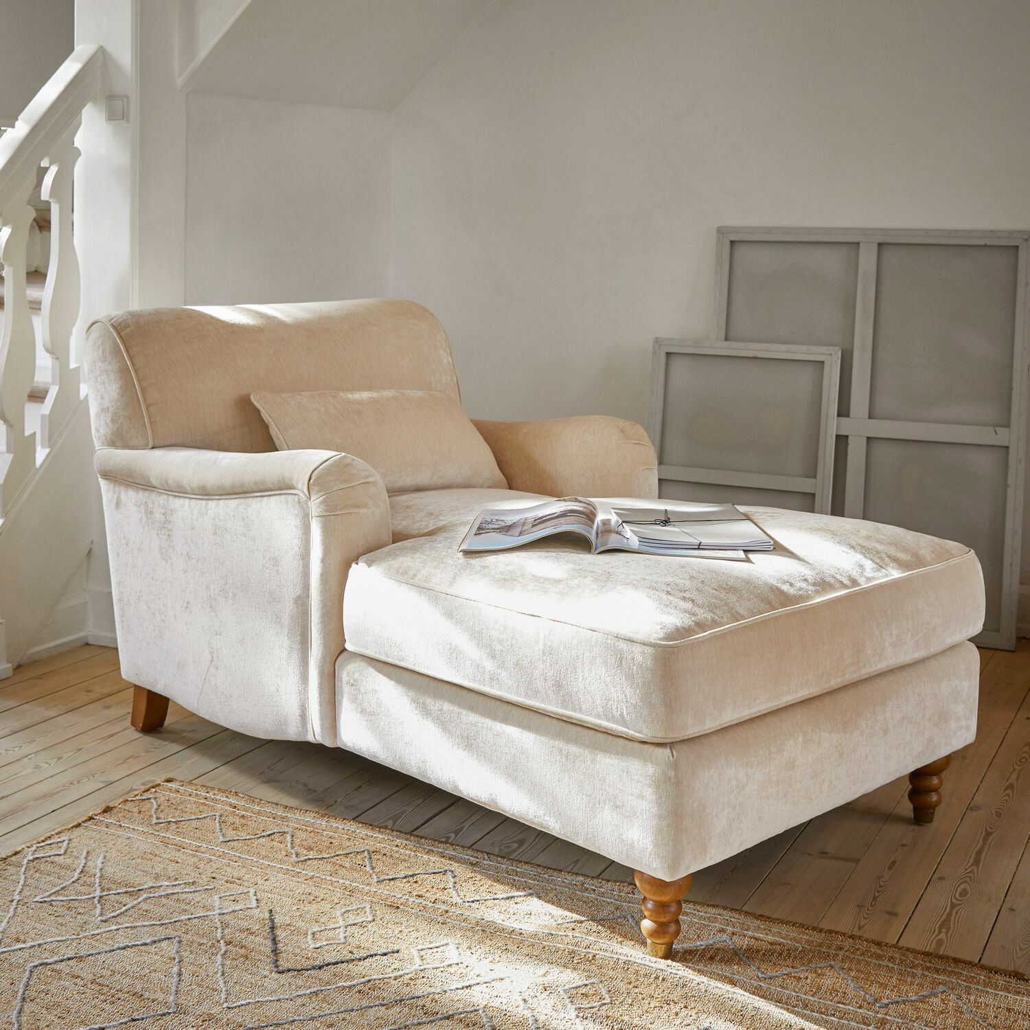 Chaiselongue Isa Beiger Sessel aus weichem Stoff mit Fußstütze und Holzbeinen in hellem Wohnzimmer