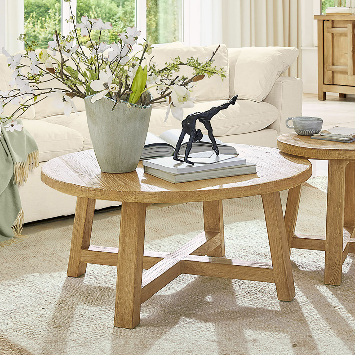 Couchtisch Gorivel Runder Couchtisch aus naturfarbenem Eichenholz mit Dekoration und Büchern im Wohnzimmer