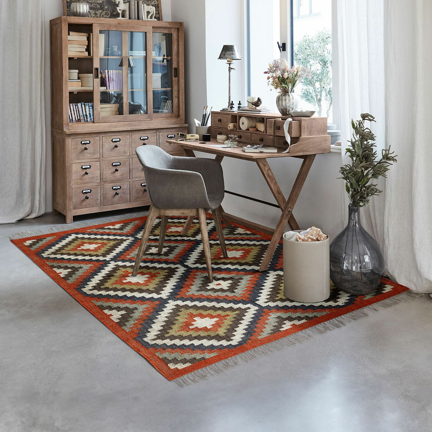 Teppich Dailies Geometrisch gemusterter Teppich in warmen Farben in modernem Arbeitszimmer mit Holzschreibtisch und grauem Stuhl