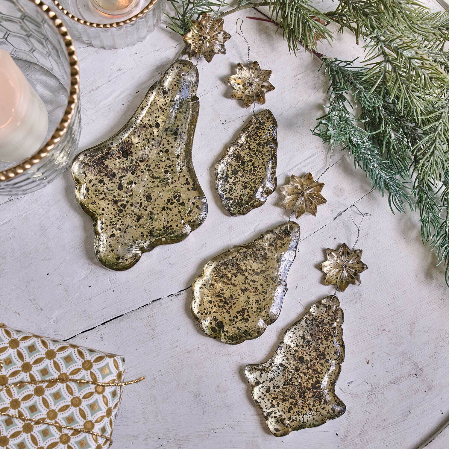 Weichnachtsschmuck 4er Set Dolenza Set aus goldfarbenen Metall-Weihnachtsanhängern in Glocken- und Sternform auf weißem Hintergrund