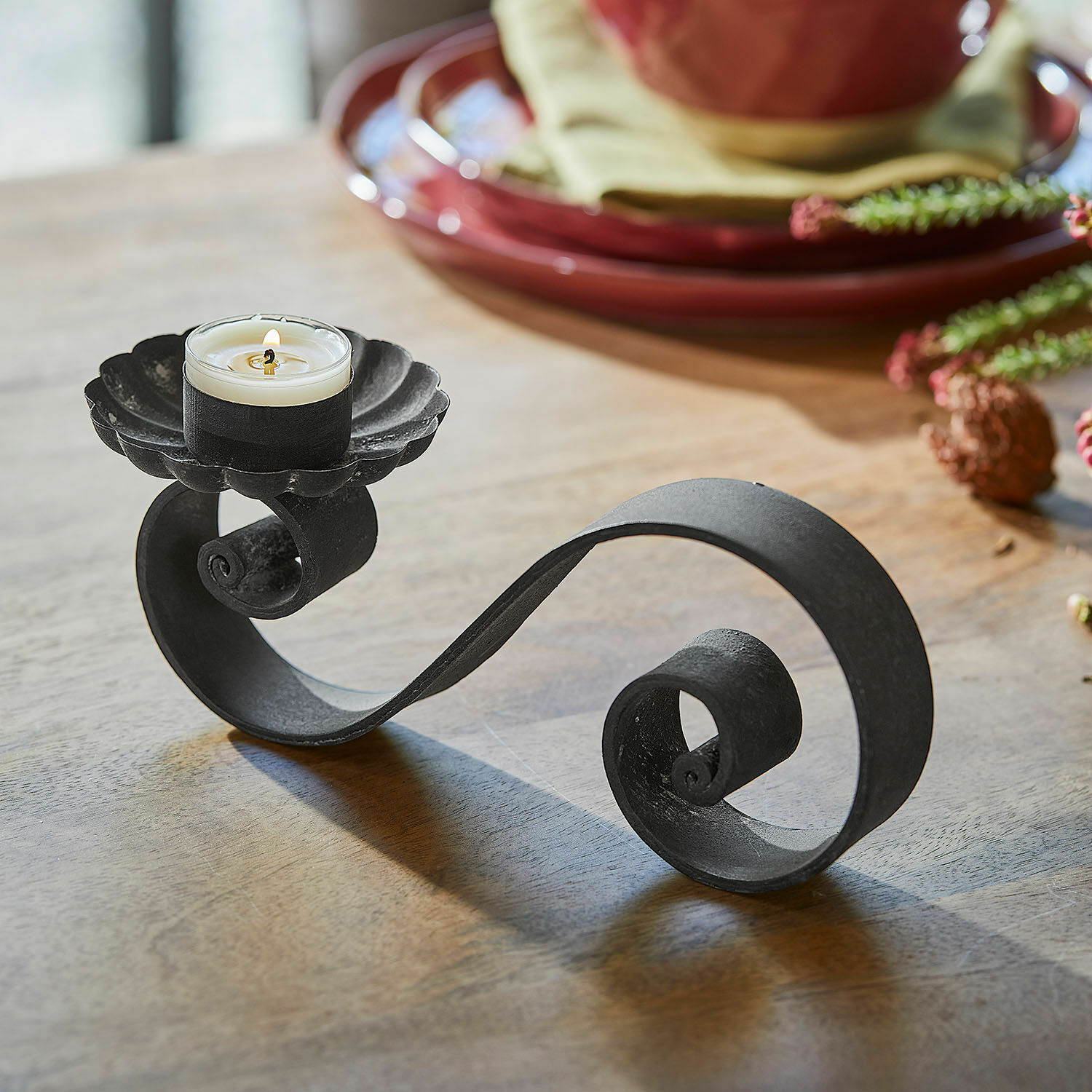 Kerzenhalter 4er Set Vorelin Schwarzer Metall-Kerzenhalter mit dekorativer Spirale und weißer Kerze auf Holztisch