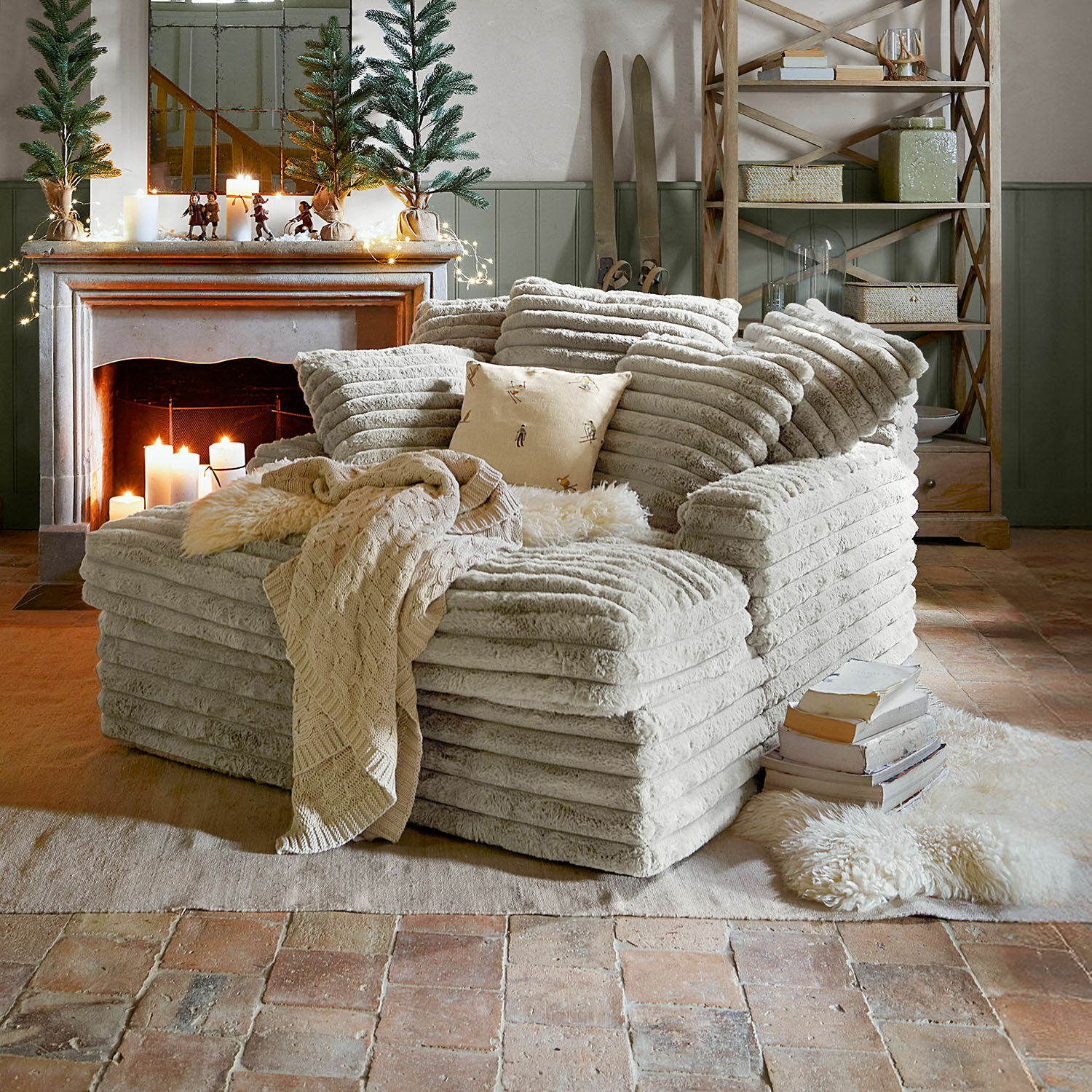 Chaiselongue Woodminster Gemütlicher Sessel aus weichem beigem Stoff in rustikalem Wohnzimmer mit Kamin und Weihnachtsdeko