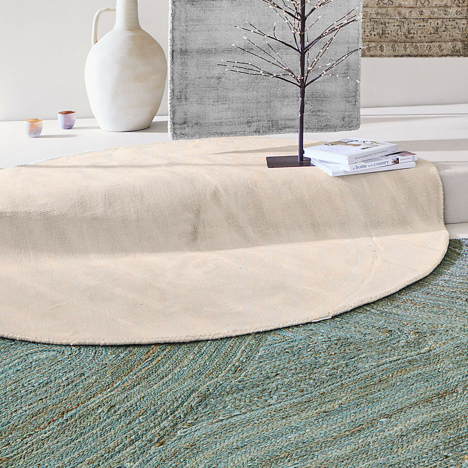 Runder beiger Teppich aus Naturmaterial auf grünem Teppich in modernem Raum