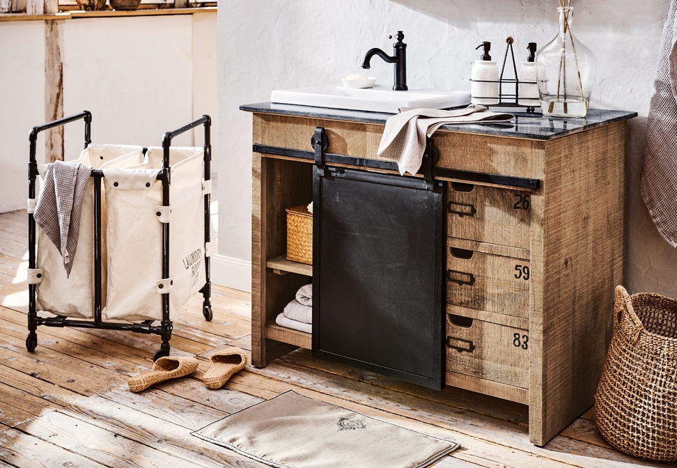 Industrielles Badezimmer mit Holzschrank, schwarzer Metallschublade und weißem Waschbecken auf Steinplatte