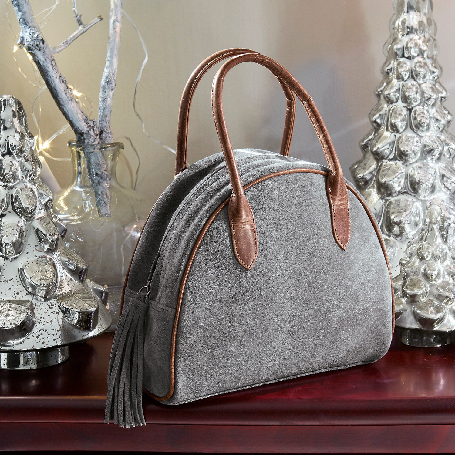 Tasche Elisabeta Graue Wildledertasche mit braunen Ledergriffen und Quaste auf Tisch mit Weihnachtsdekoration