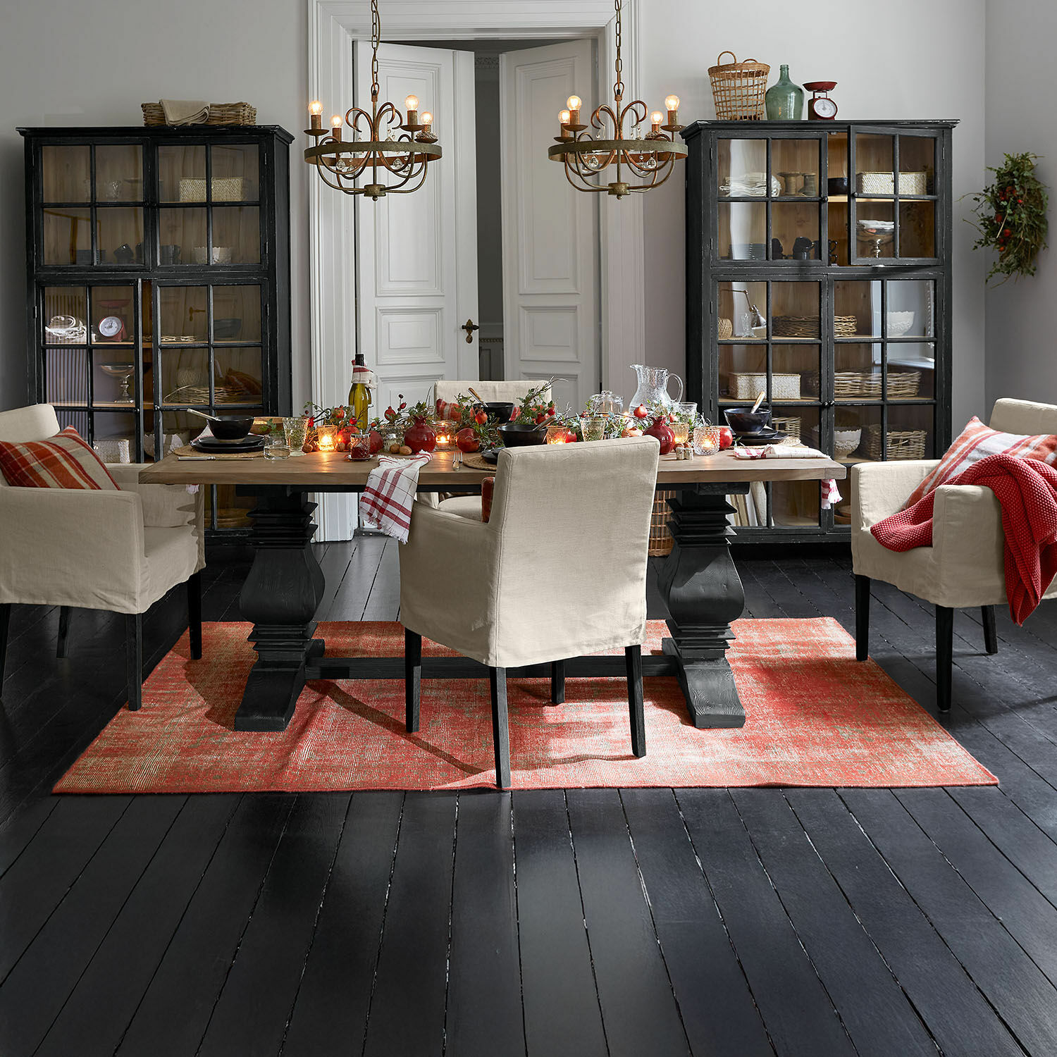 Esszimmer mit Holztisch, beigen Stühlen und rotem Teppich auf schwarzem Boden, festliche Tischdekoration