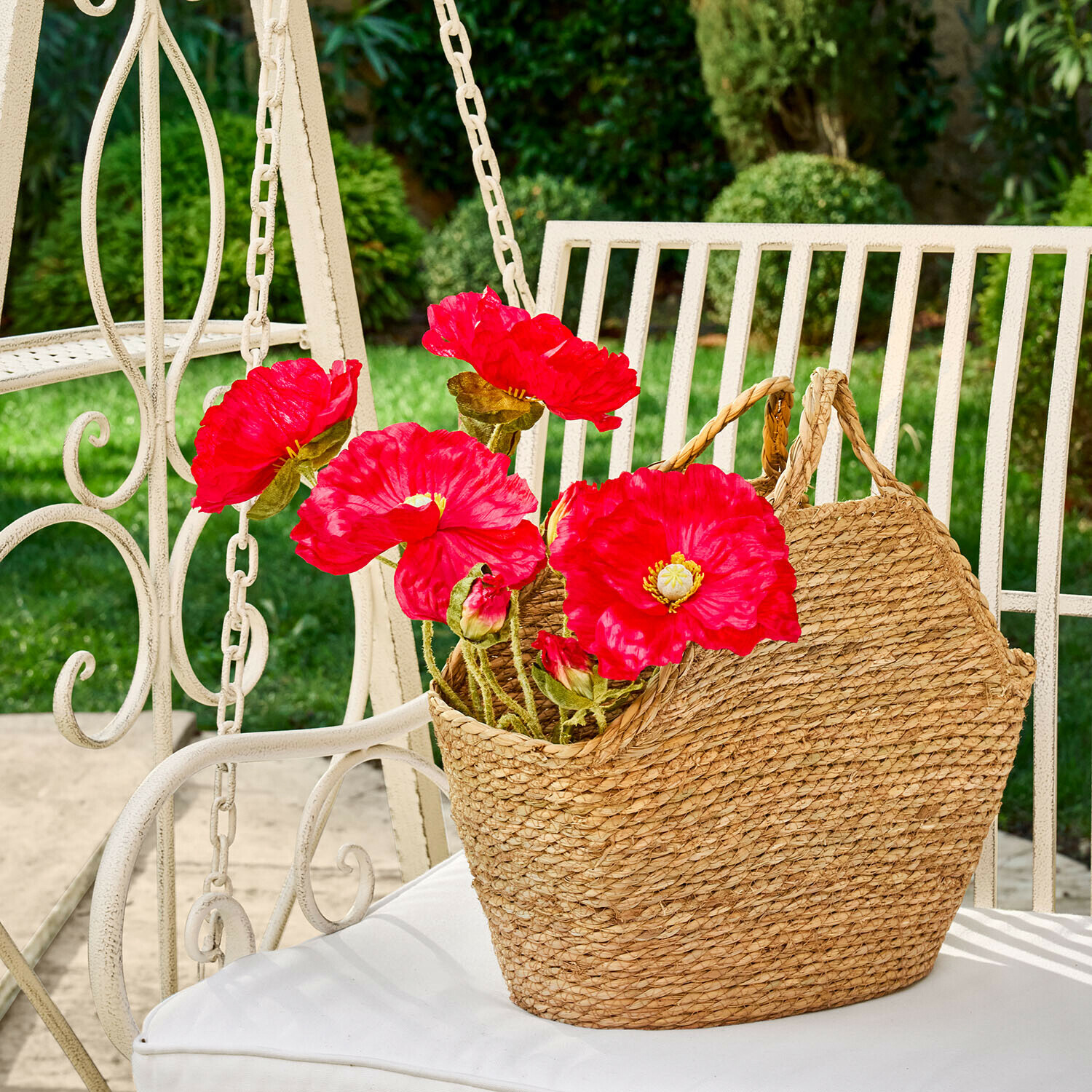 Deko-Blume 4er Set Doravela Naturfarbener geflochtener Seegras-Korb mit roten Blumen auf weißem Gartenstuhl