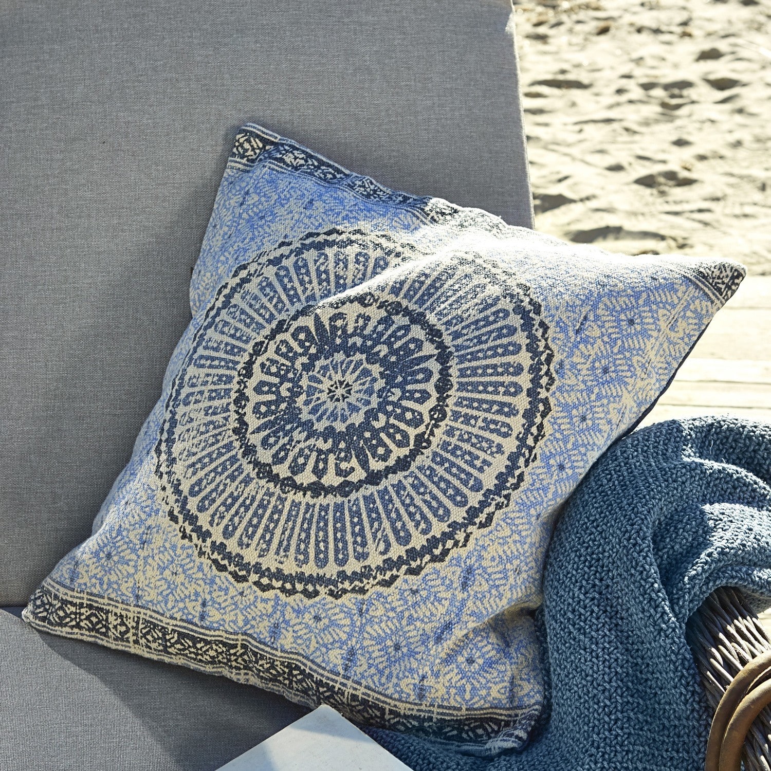 Kissen Kelcie Dekoratives Baumwollkissen in Blau-Beige mit orientalischem Muster auf grauem Sofa