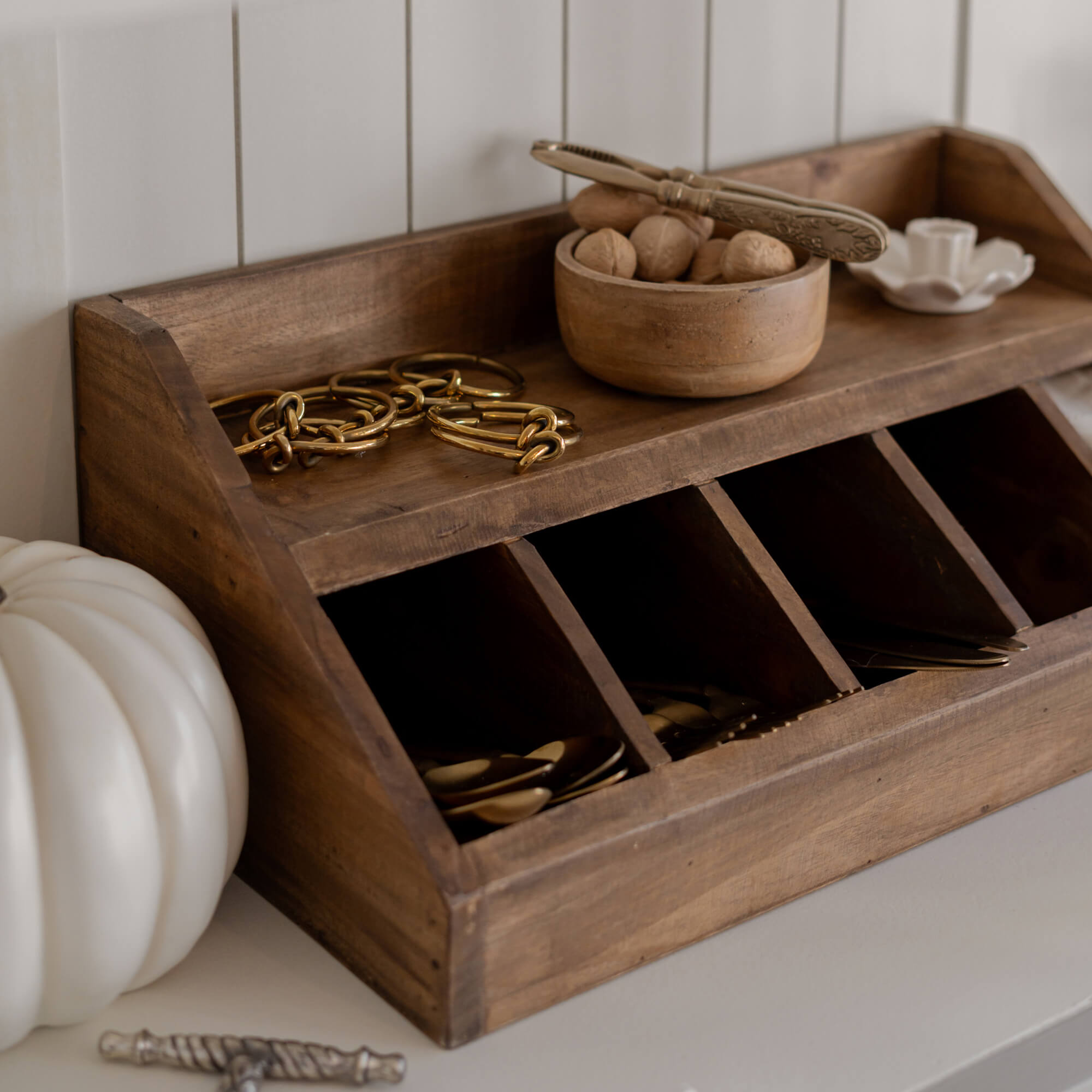 Holz-Organizer mit Fächern und Schale mit Nüssen auf hellem Untergrund zur Aufbewahrung von Kleinteilen