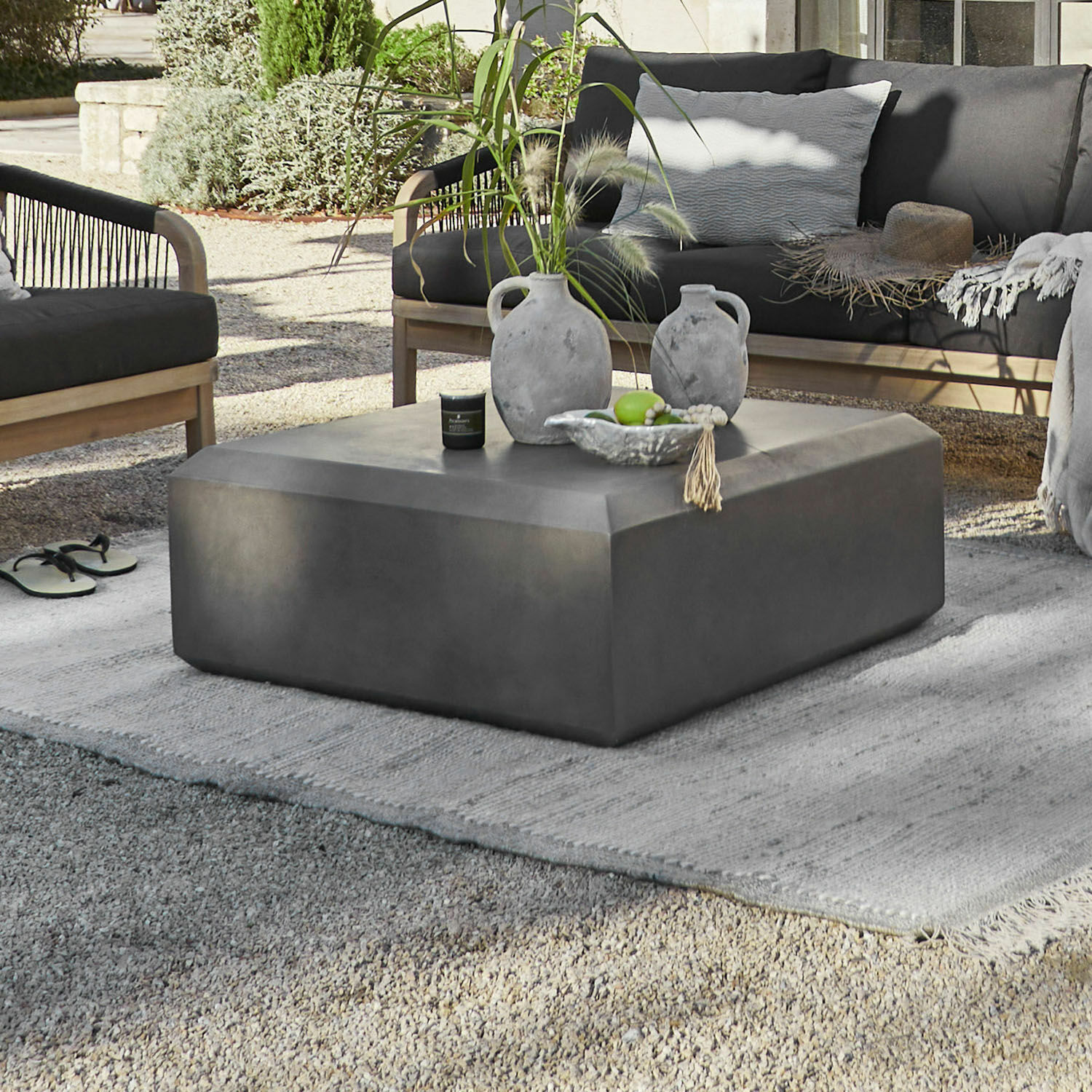Couchtisch Theodoros Moderner grauer Beton-Couchtisch im Außenbereich mit Dekoration und Gartenmöbeln