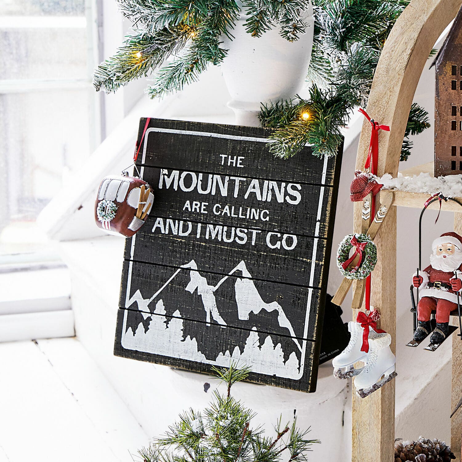 Dekoboard Mountain Holz-Wanddekoration mit Bergmotiv und Schriftzug, geschmückt mit Tannenzweigen und Weihnachtsanhängern