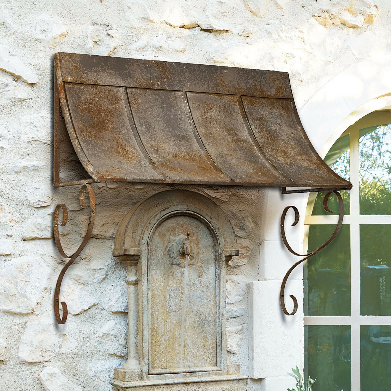 Rustikaler Metallvordach in Rostoptik über einem steinernen Außenbrunnen