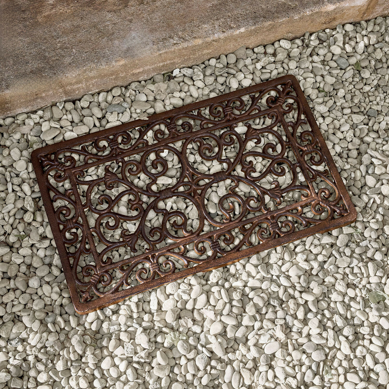 Schuhabstreifer Fyloran Braune Metallmatte mit dekorativem Muster auf weißen Steinen, gusseiserne Fußmatte