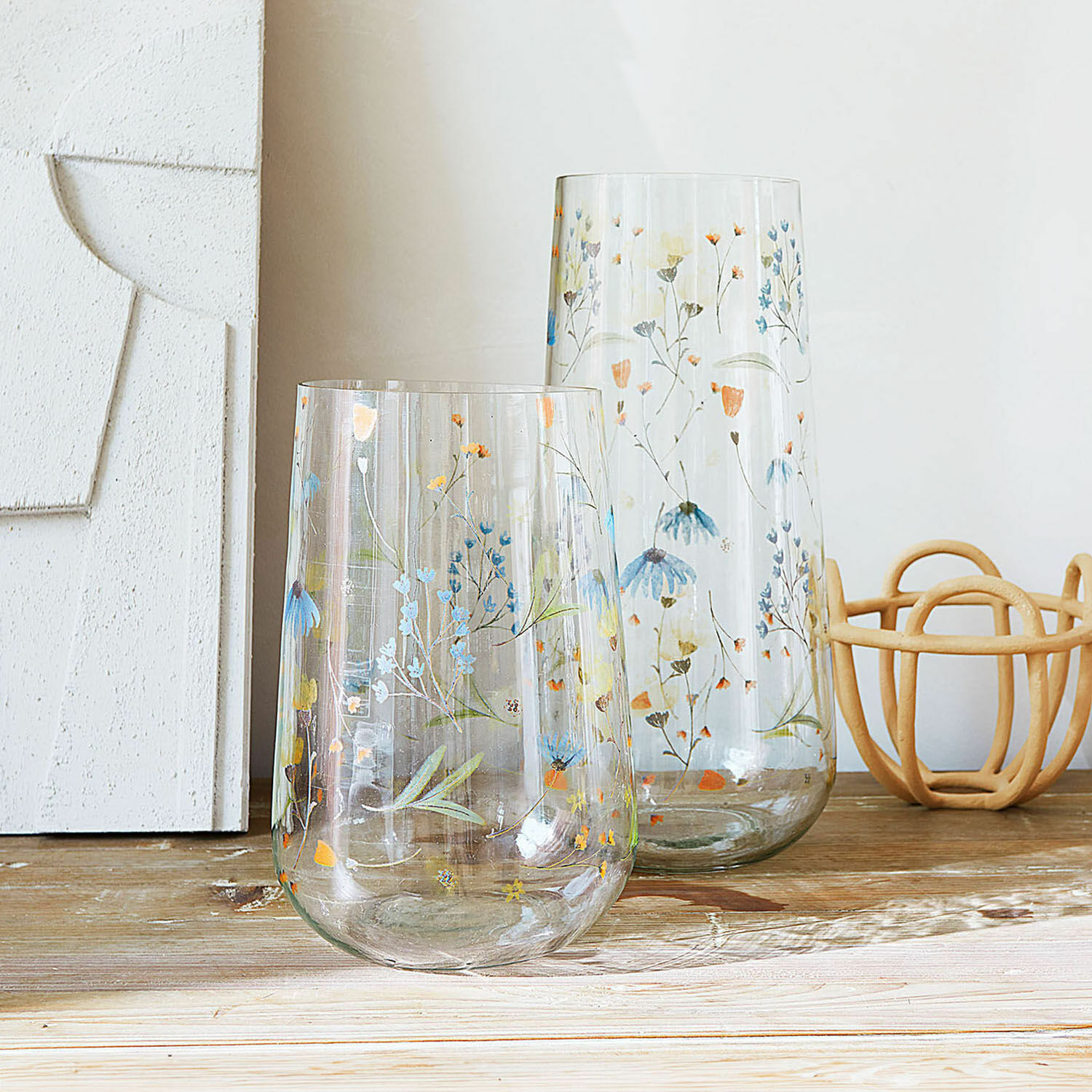 Vase 2er Set Nervila Zwei transparente Glasvasen mit buntem Blumenmuster auf Holztisch dekorativ arrangiert