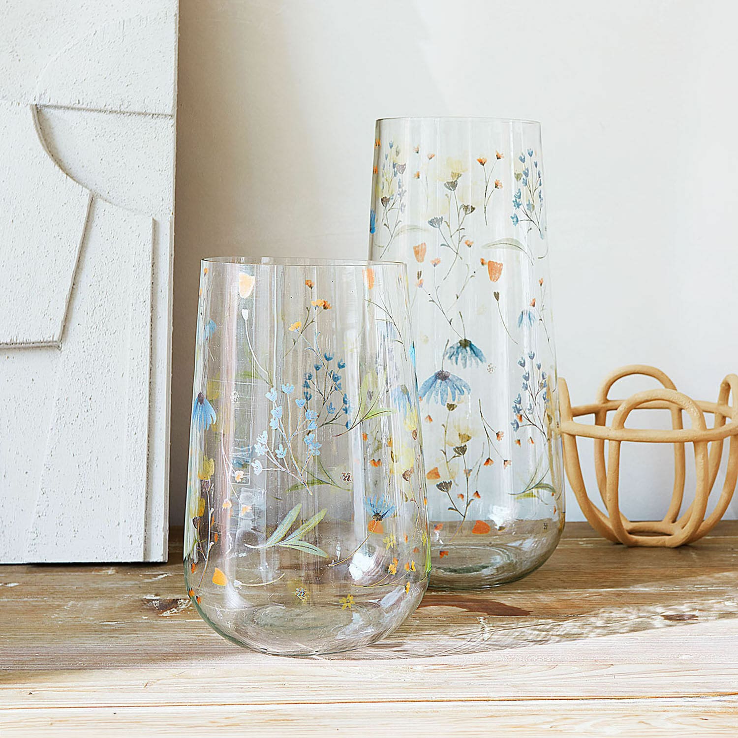 Vase 2er Set Nervila Zwei transparente Glasvasen mit buntem Blumenmuster auf Holztisch dekorativ arrangiert