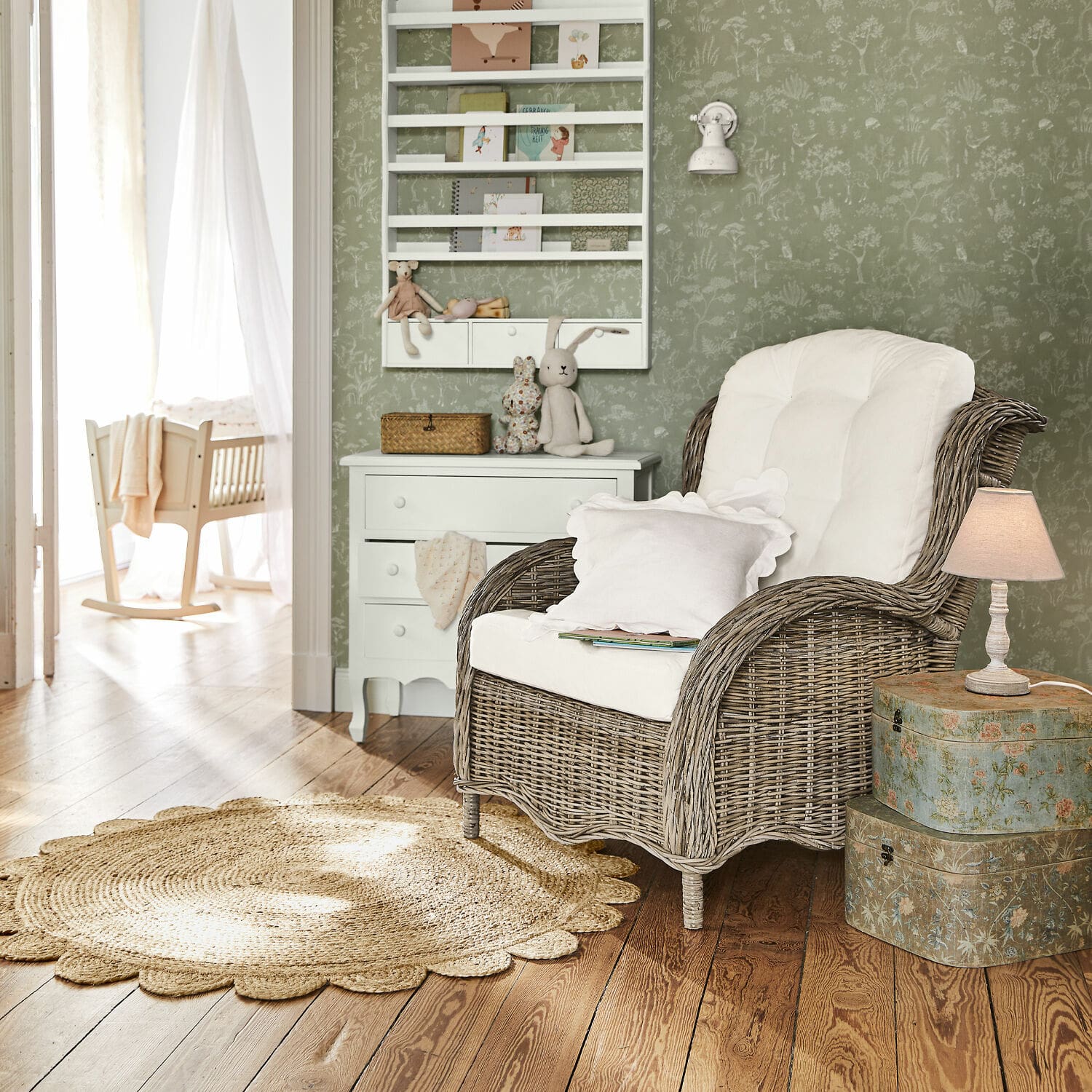 Teppich Ferce Rattansessel mit weißem Polster in gemütlichem Raum mit grüner Tapete und Holzboden
