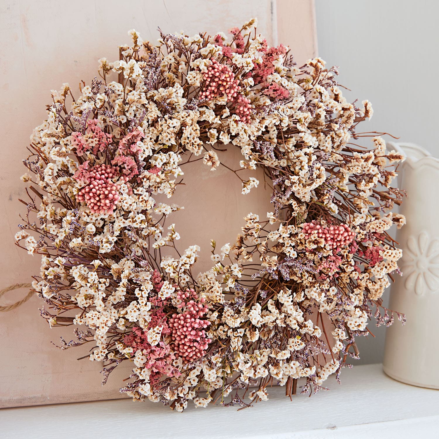 Kranz aus getrockneten cremefarbenen und rosa Blumen als natürliche Wohnraumdekoration