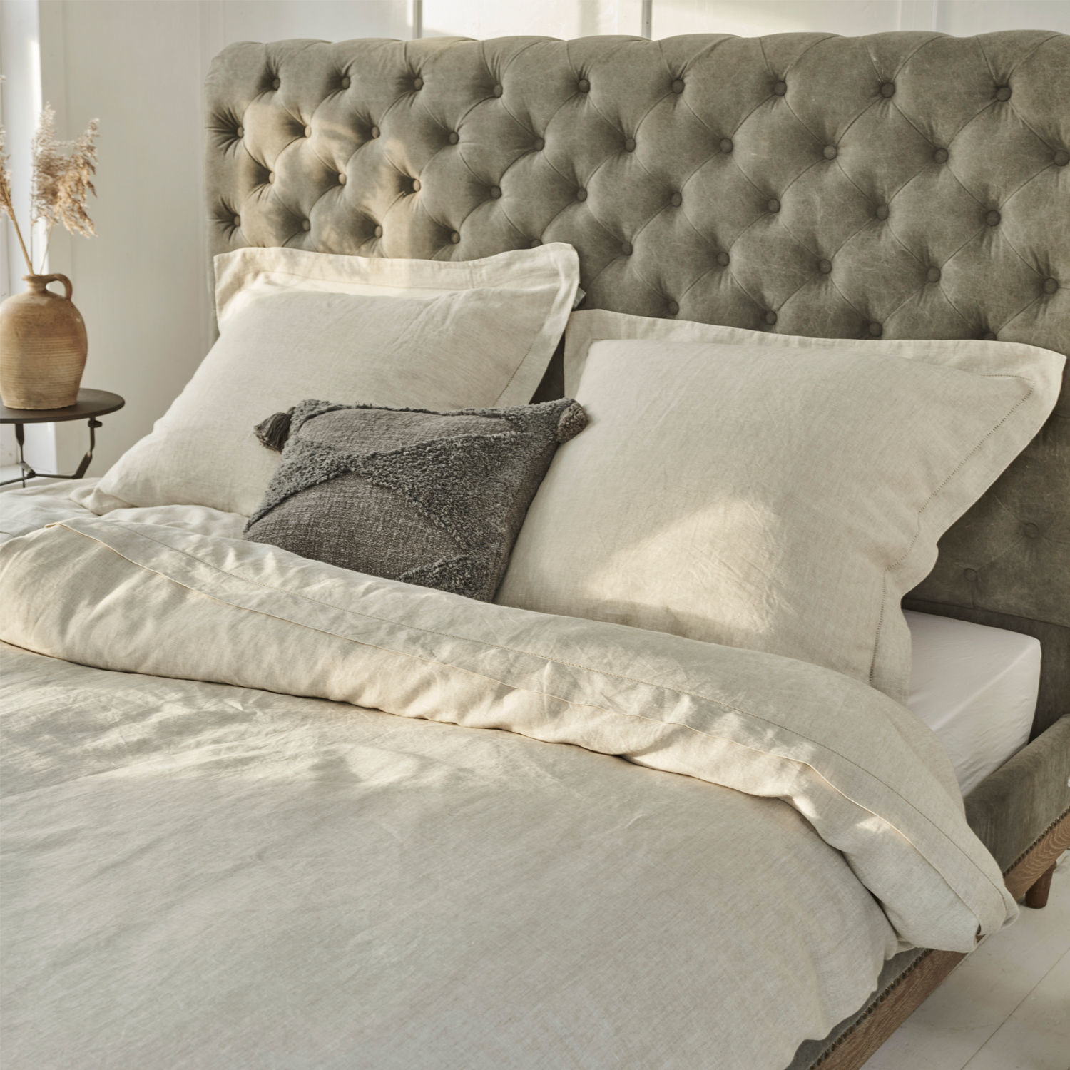 Bettwäsche Kilanema Beige Leinenbettwäsche auf Bett mit grauem, gestepptem Kopfteil, graues Dekokissen
