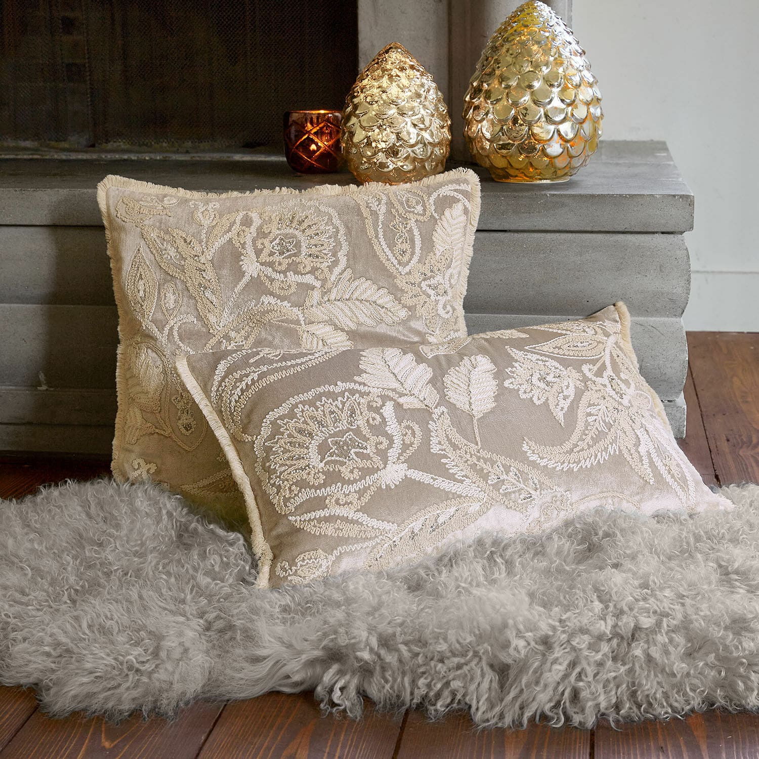Kissenhülle 2er Set Oplevine Beige bestickte Dekokissen auf grauem Fellteppich vor Kamin, Wohntextilien für gemütliche Räume
