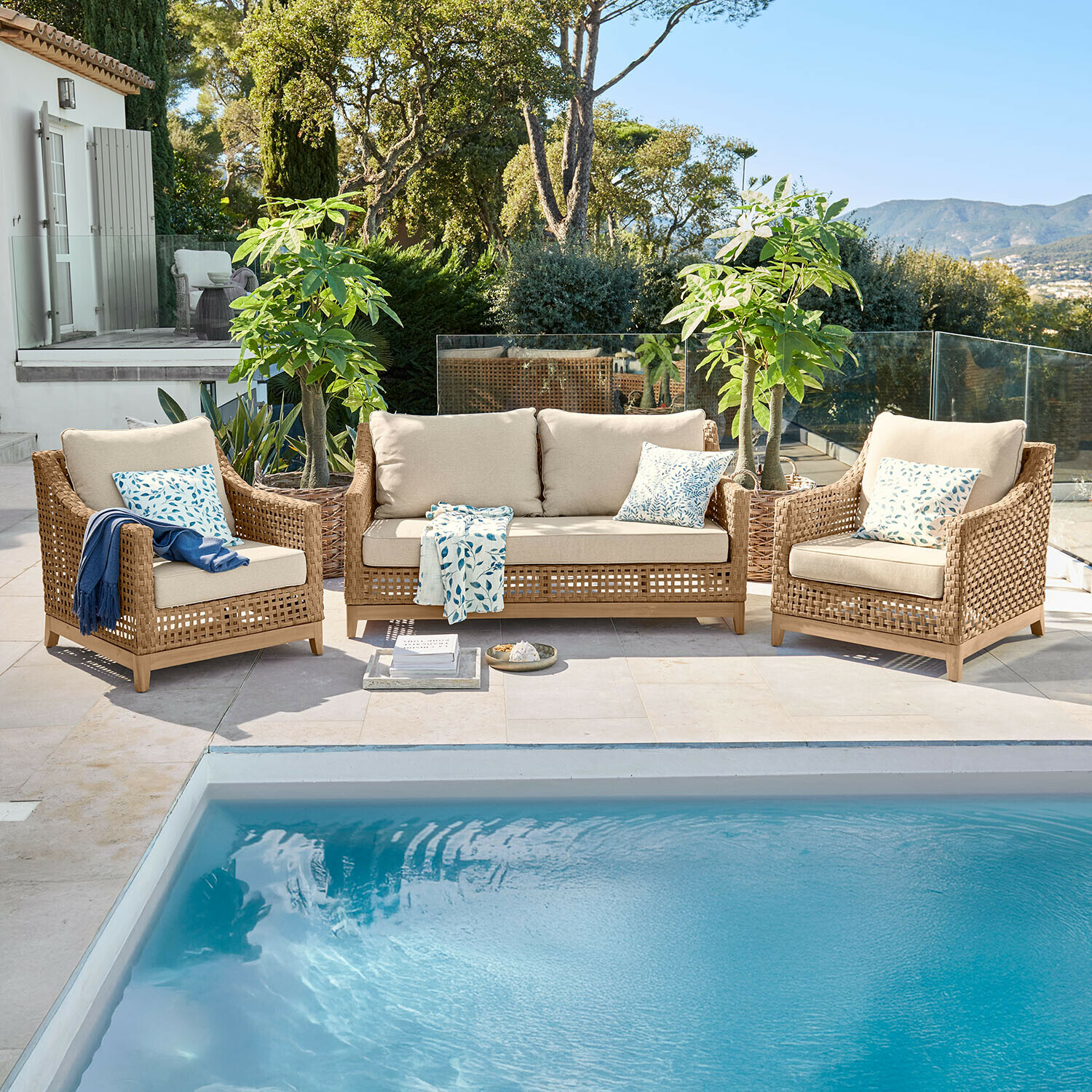Sitzgruppe Isolara Gartenmöbel-Set aus braunem Rattan mit beigen Polstern neben einem Pool im Freien