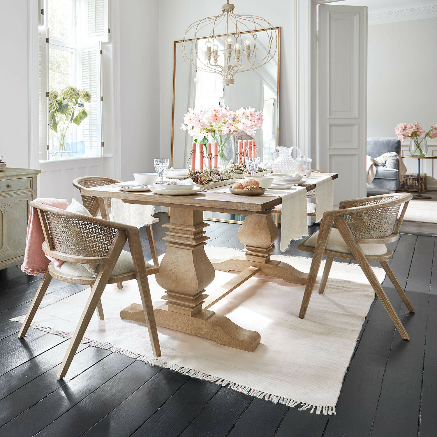 Esstisch Cain Heller Holzesstisch mit Rattanstühlen und Tischdekoration in modernem Esszimmer