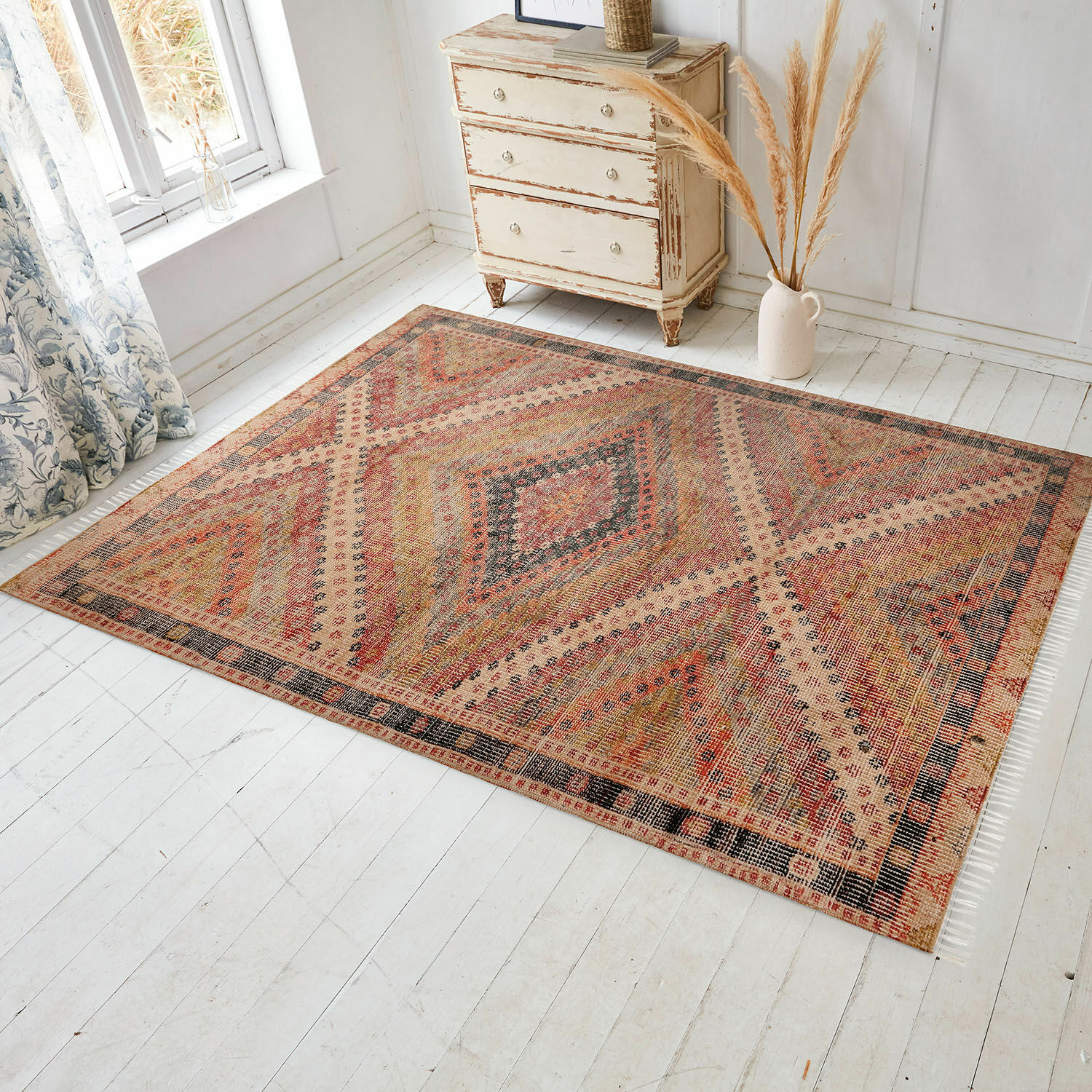 In- & Outdoor-Teppich Mildura Teppich mit geometrischem Muster in warmen Rot- und Beigetönen auf hellem Boden im Raum