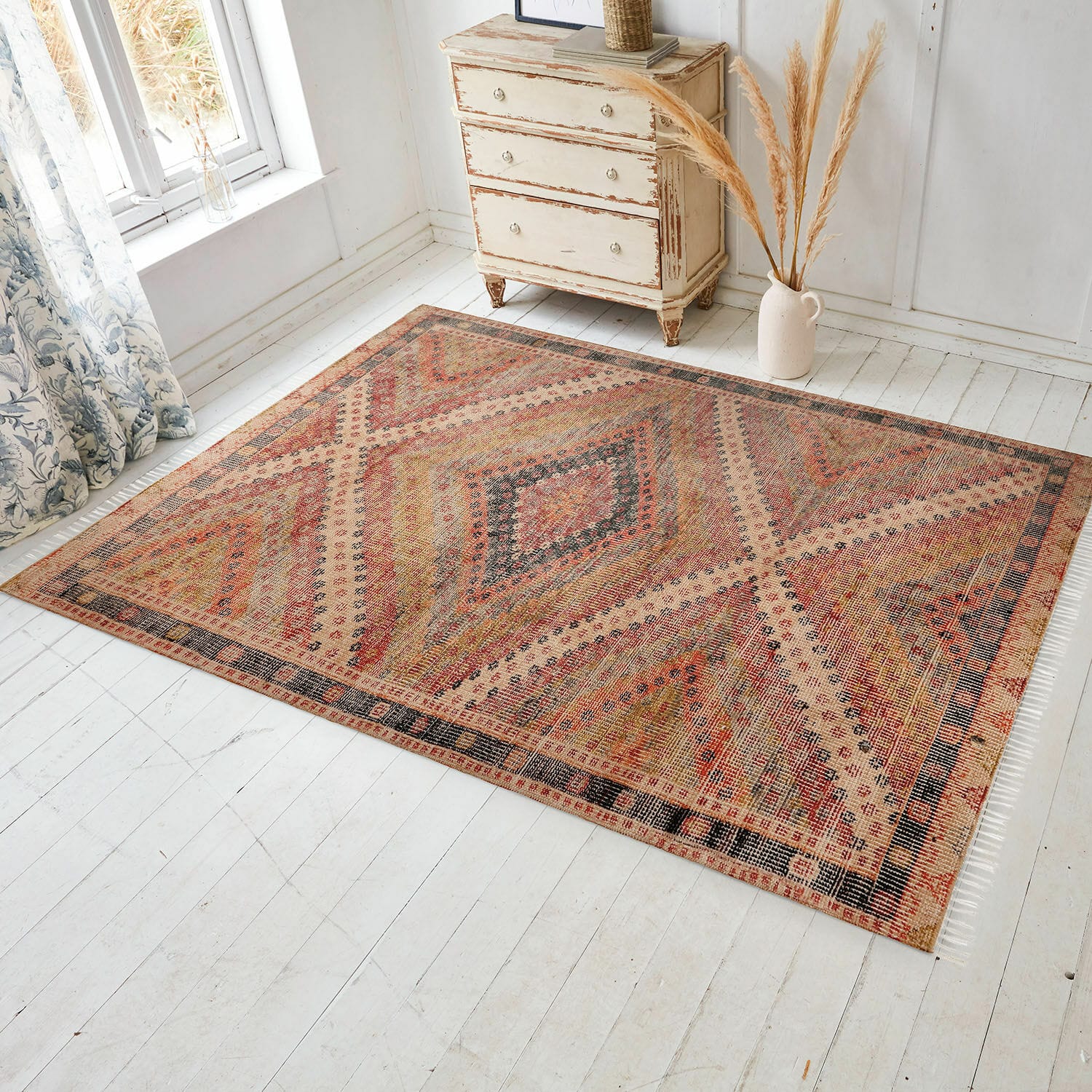 In- & Outdoor-Teppich Mildura Teppich mit geometrischem Muster in warmen Rot- und Beigetönen auf hellem Boden im Raum