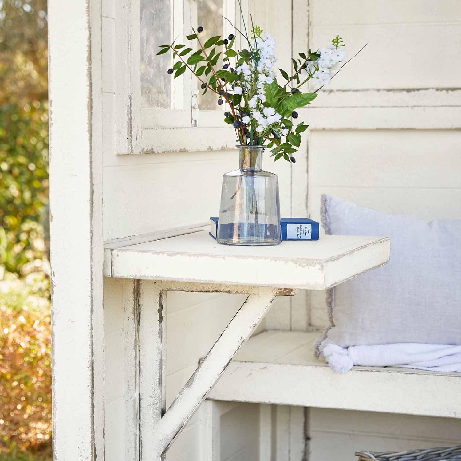 Weißer klappbarer Holztisch mit klarem Glasvase und Blumen, Garten-Dekoration