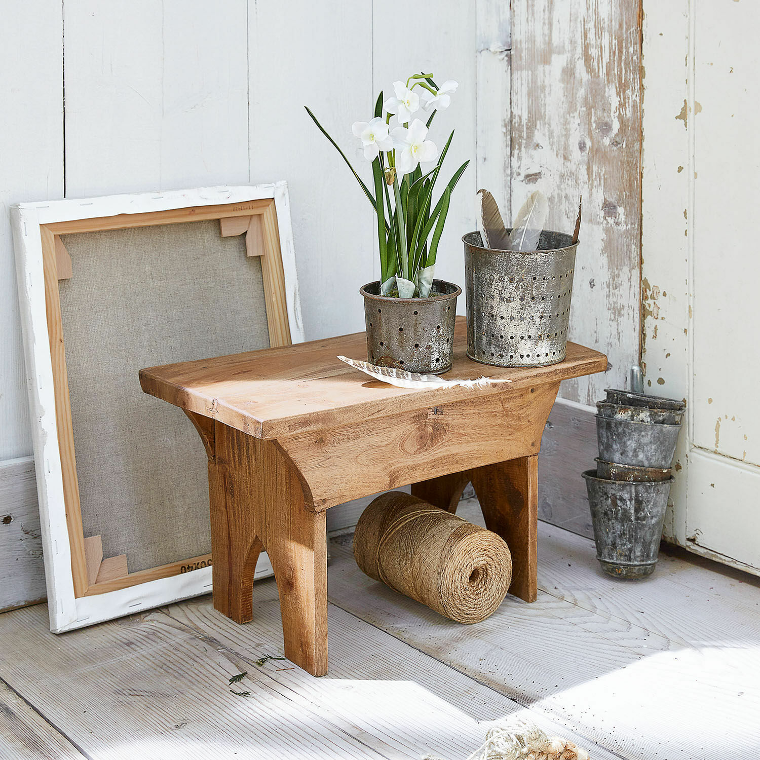 Hocker Hoboken Kleiner Holzschemel mit Metalltöpfen und weißen Blumen auf hellem Holzboden
