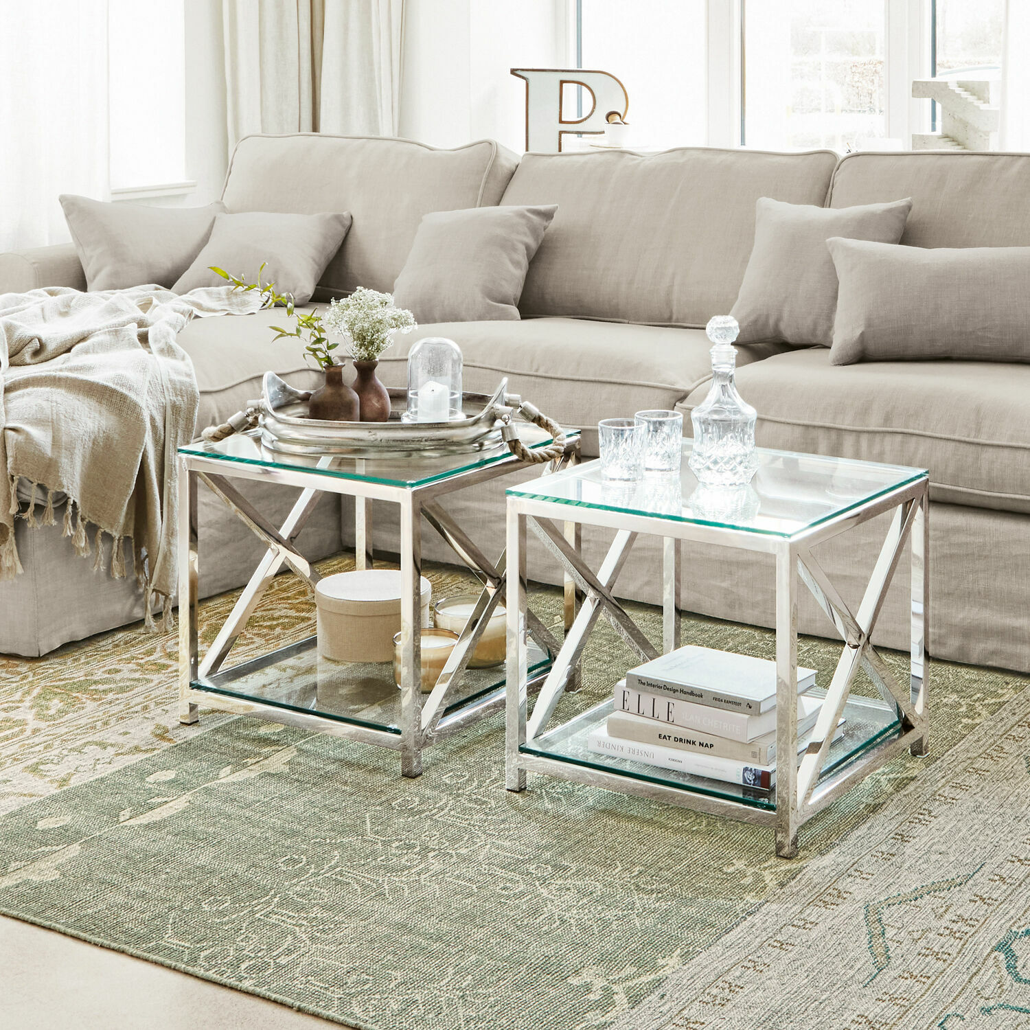 Beistelltisch Stamford Zweier-Set Couchtische mit Glasplatte und silbernem Metallgestell auf grünem Teppich
