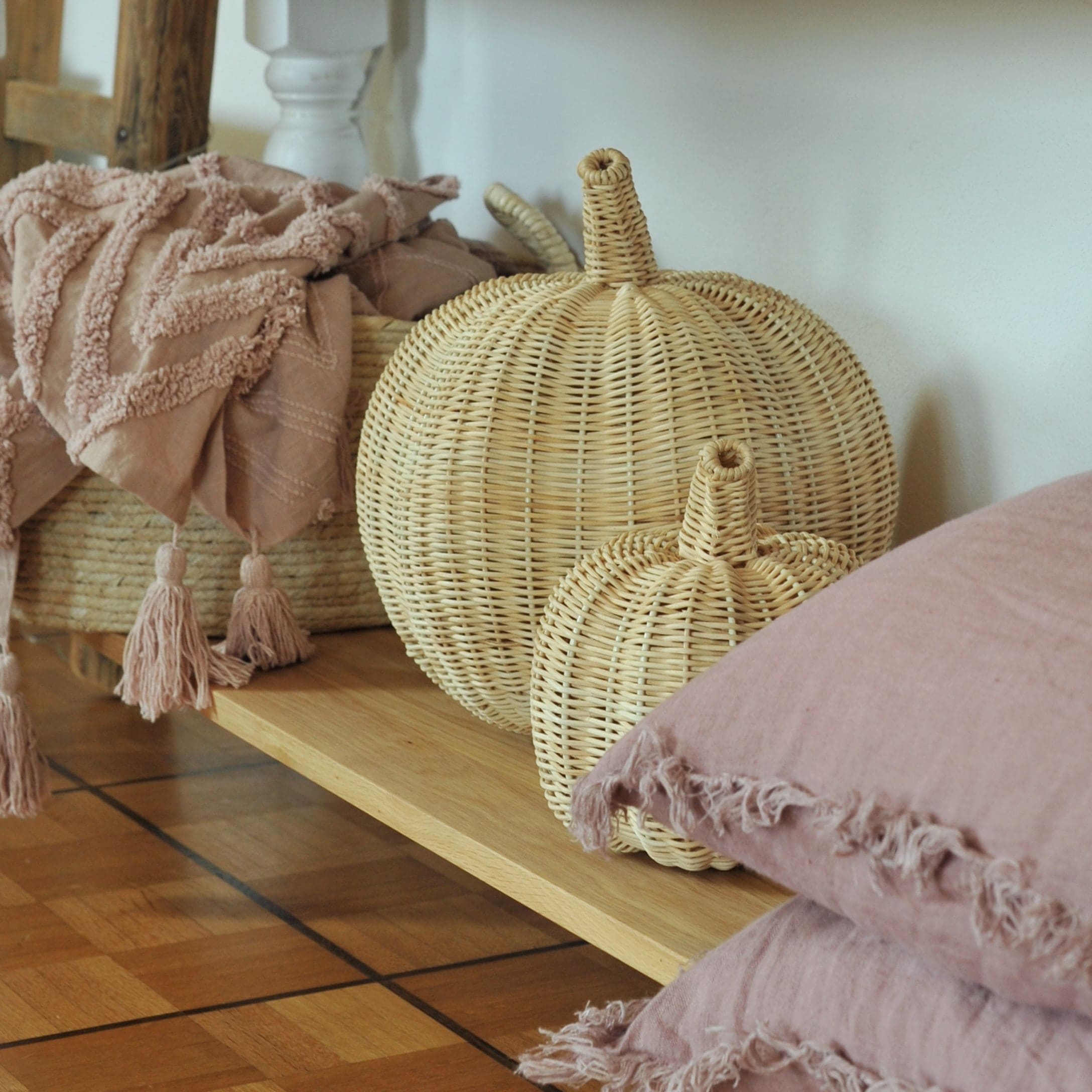 Dekorative Rattan-Kürbisse in Naturfarbe auf Holzregal im Boho-Stil