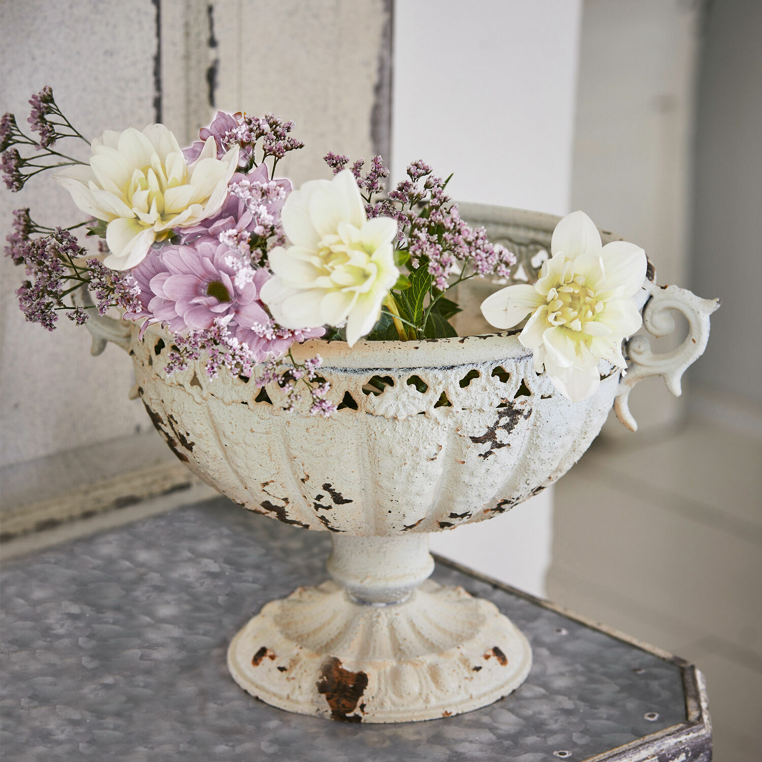 Amphore Vescemont Weiße Metall-Schale mit antikem Look und pastellfarbenen Blumen auf dekorativem Tisch