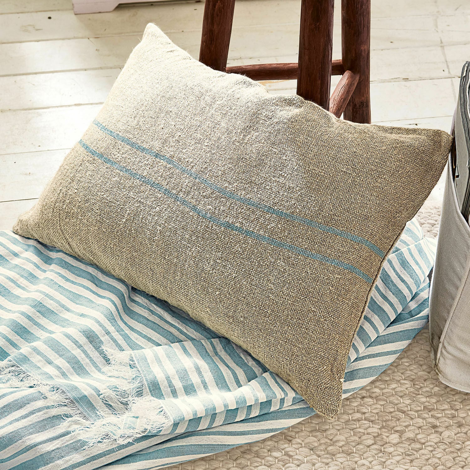 Kissenhülle Arrentès Beige Leinenkissen mit blauen Streifen auf blau-weiß gestreiftem Decke, gemütliche Wohnaccessoires
