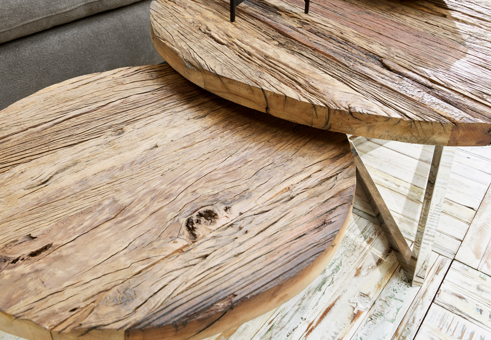 Zwei runde Tische aus naturbelassenem Holz mit sichtbarer Maserung und Metallbeinen im Industriestil