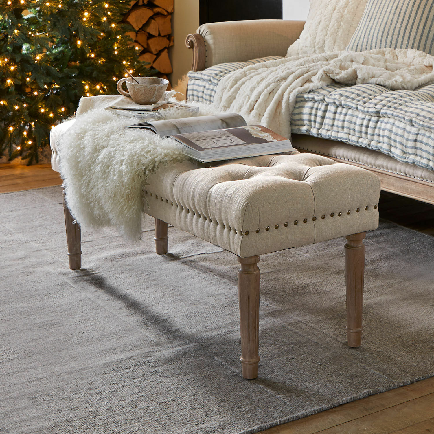 Bank Brookfield Beige gepolsterte Bank mit Holzbeinen auf grauem Teppich in gemütlichem Wohnzimmer mit Weihnachtsbaum